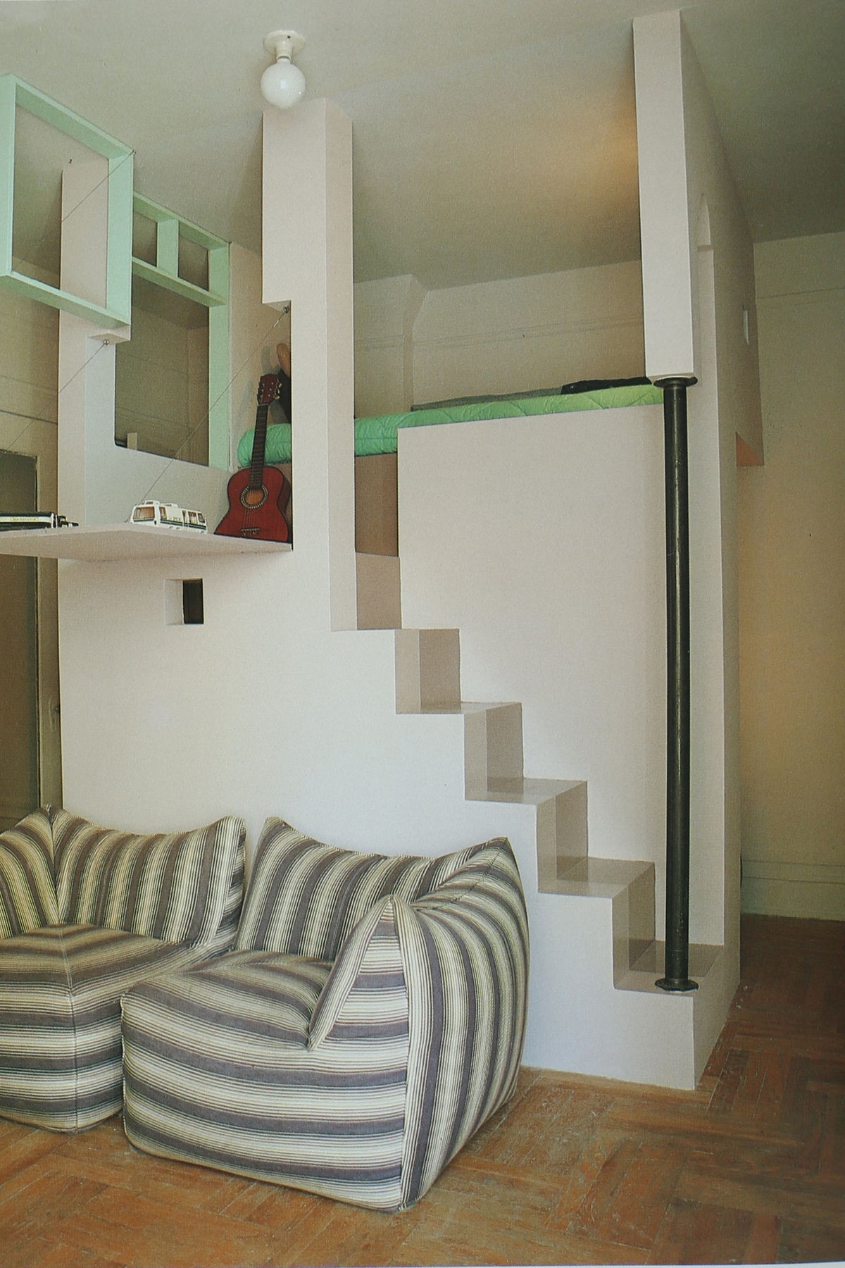Modern loft interior with striped sofa and geometric stairs
