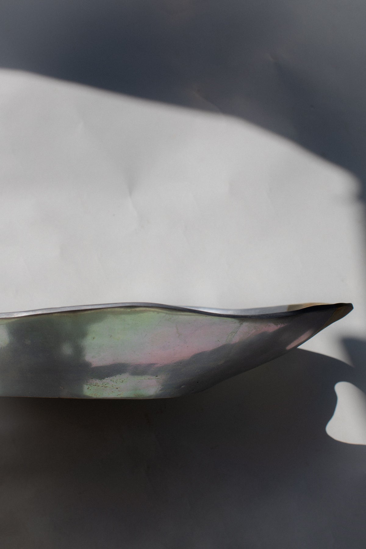 Iridescent brutalist bowl showing curved metallic interior detail