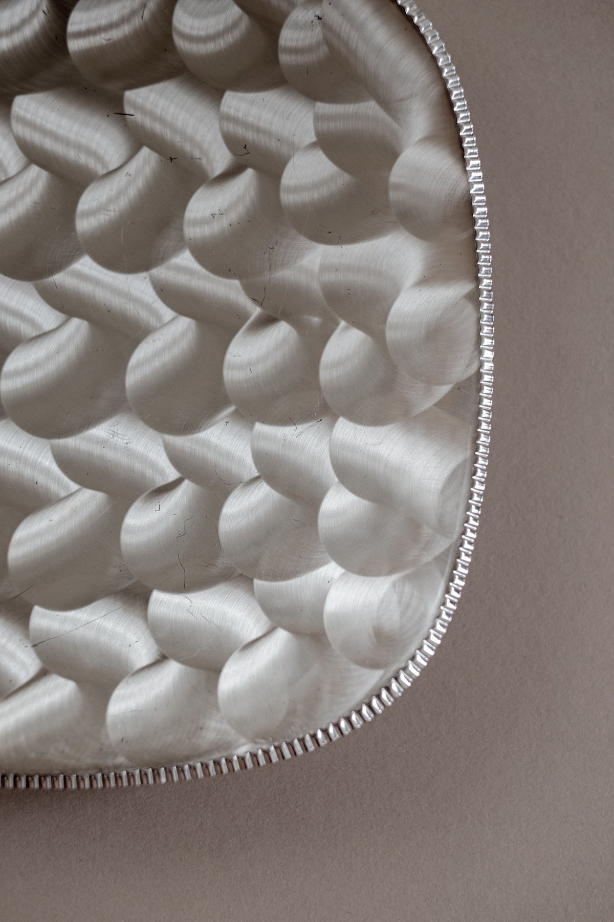 Close-up detail of textured silver-plated decorative dish surface
