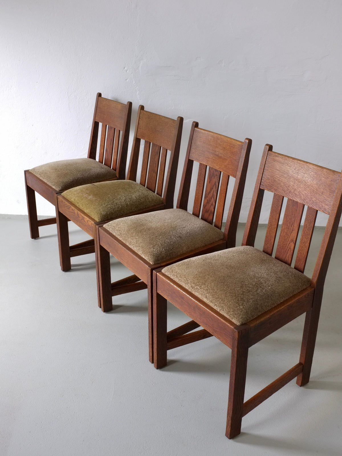 Set of four Arts & Crafts oak dining chairs with green upholstery
