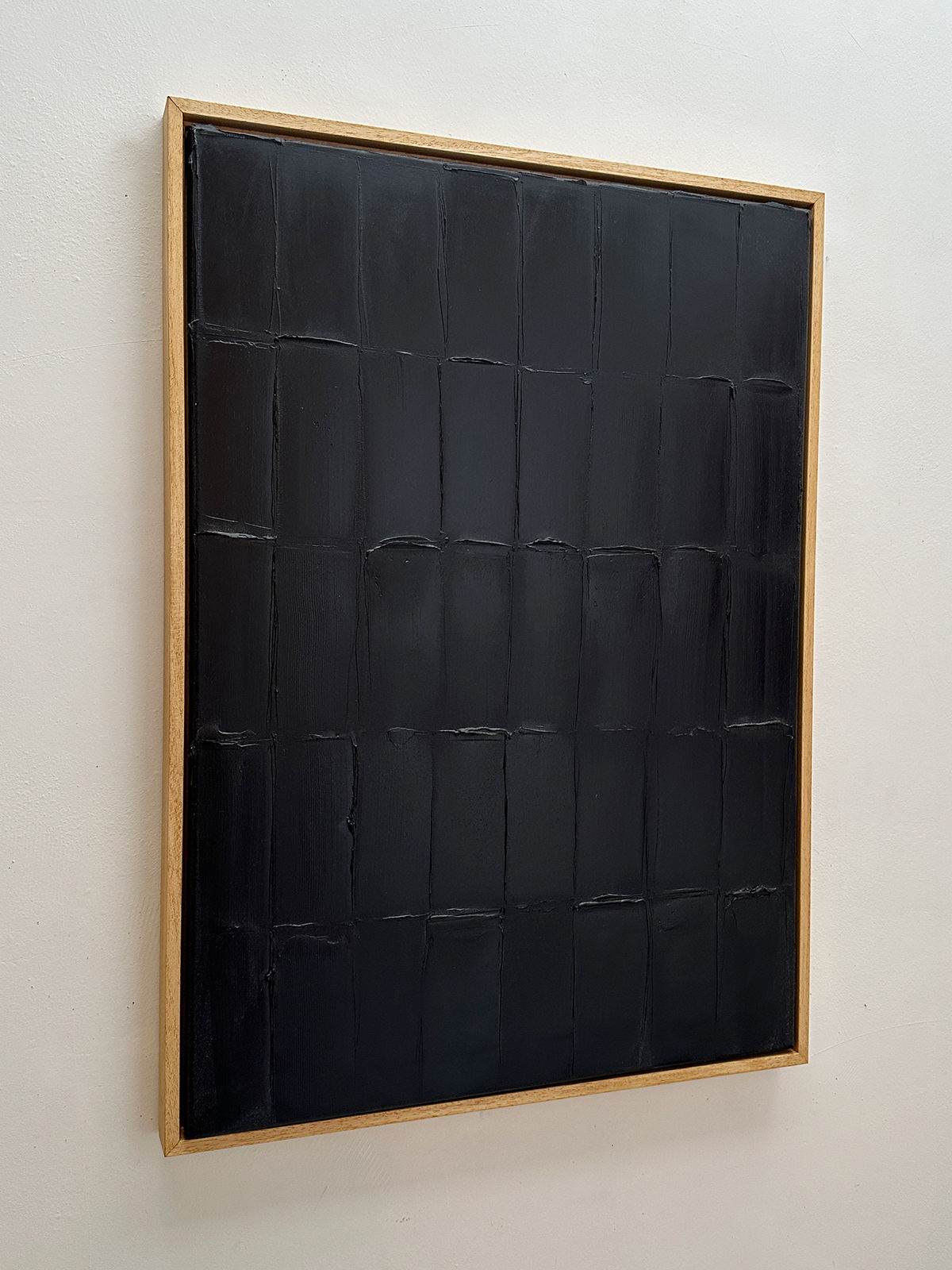 Black textured grid painting with thick brushstrokes by Roi Elmaliah