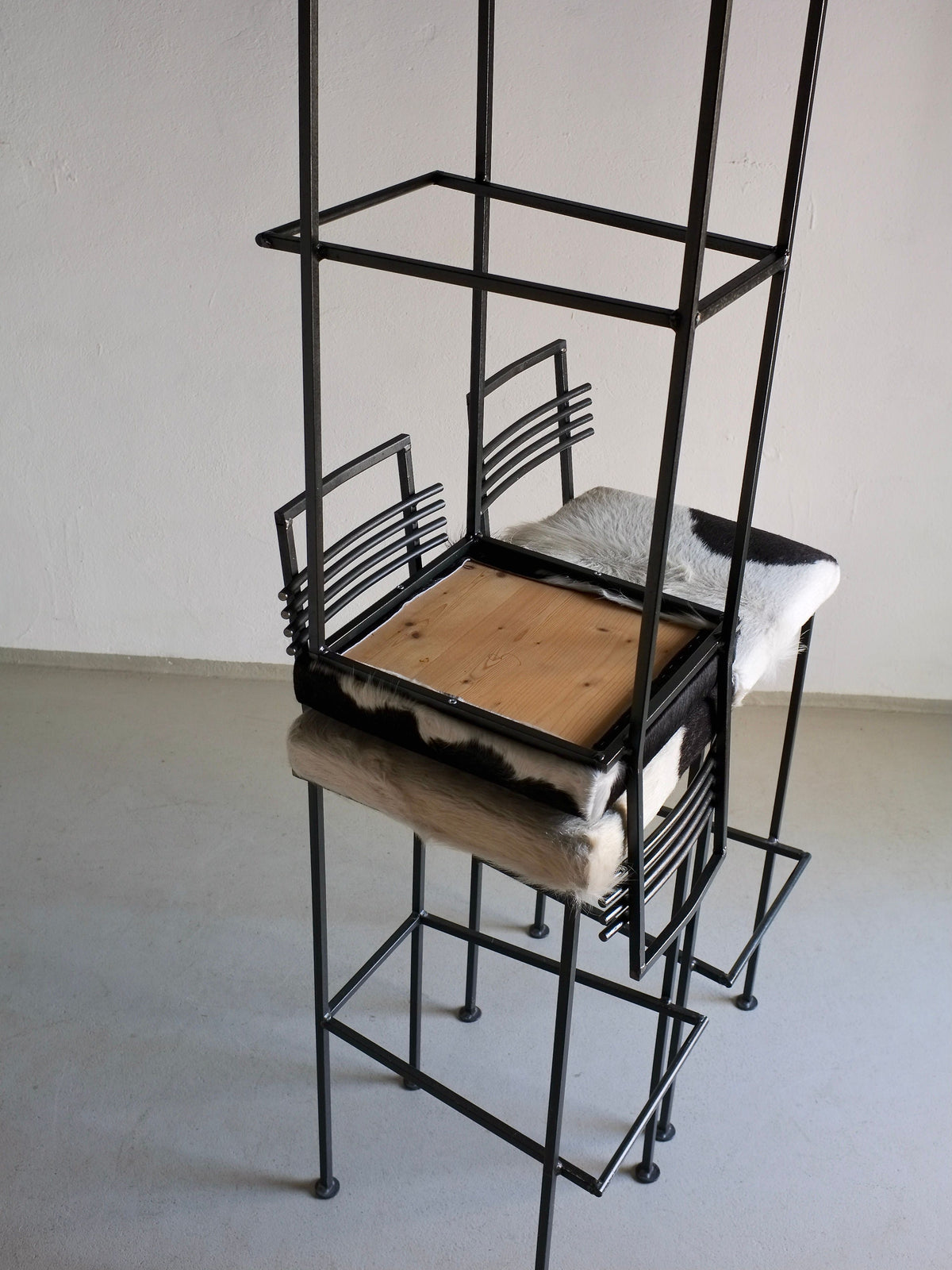 Stacked wrought iron bar stools with cowhide seats detail view
