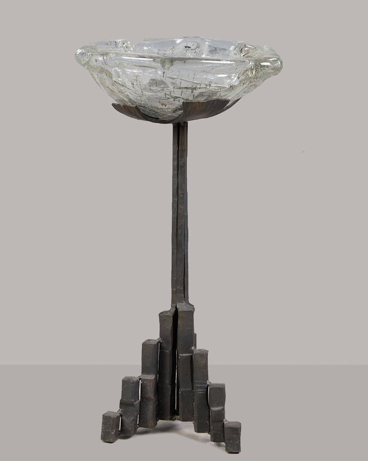 Brutalist iron candle stand with geometric base and glass bowl