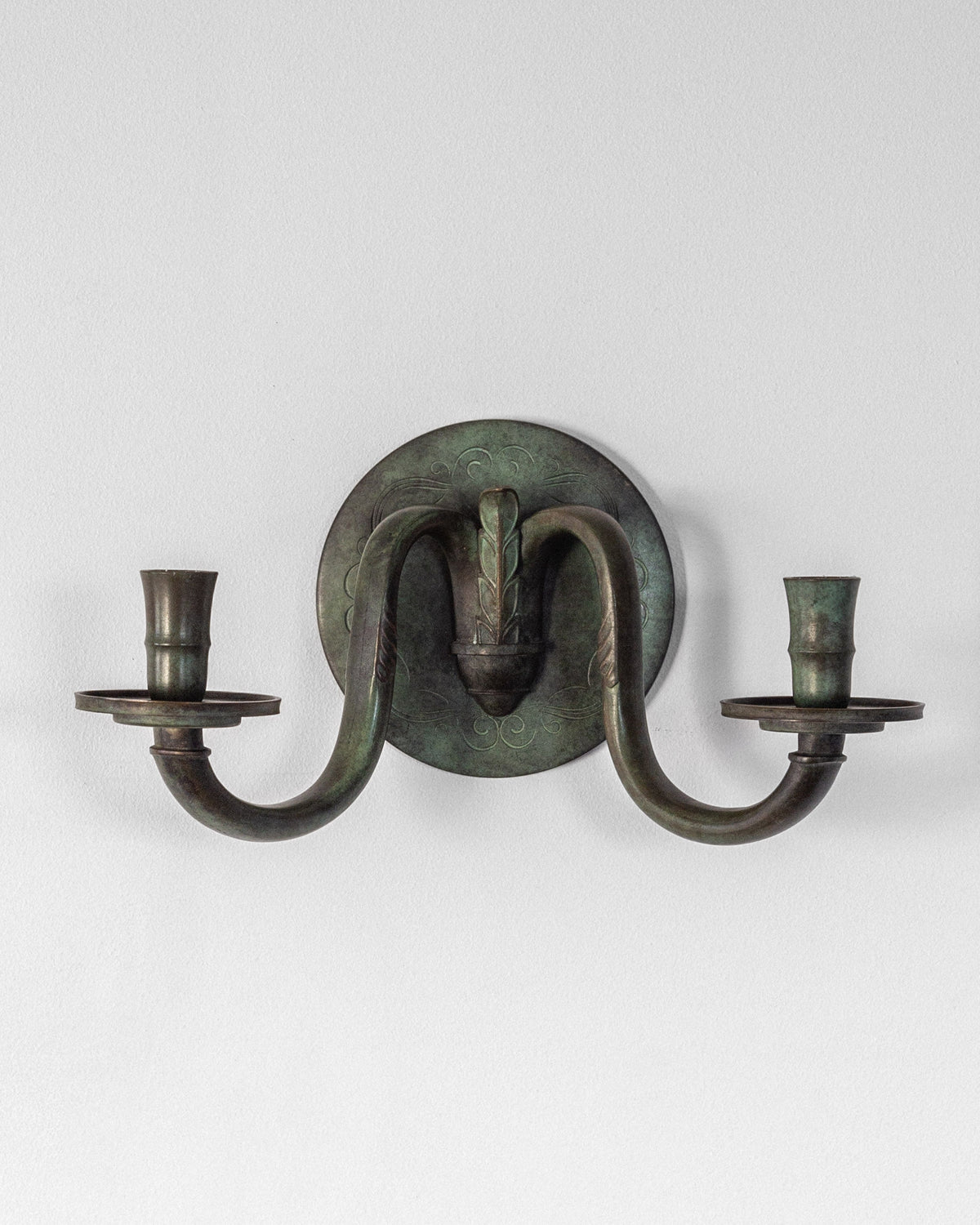 Art Deco bronze wall sconce with curved arms and candle holders
