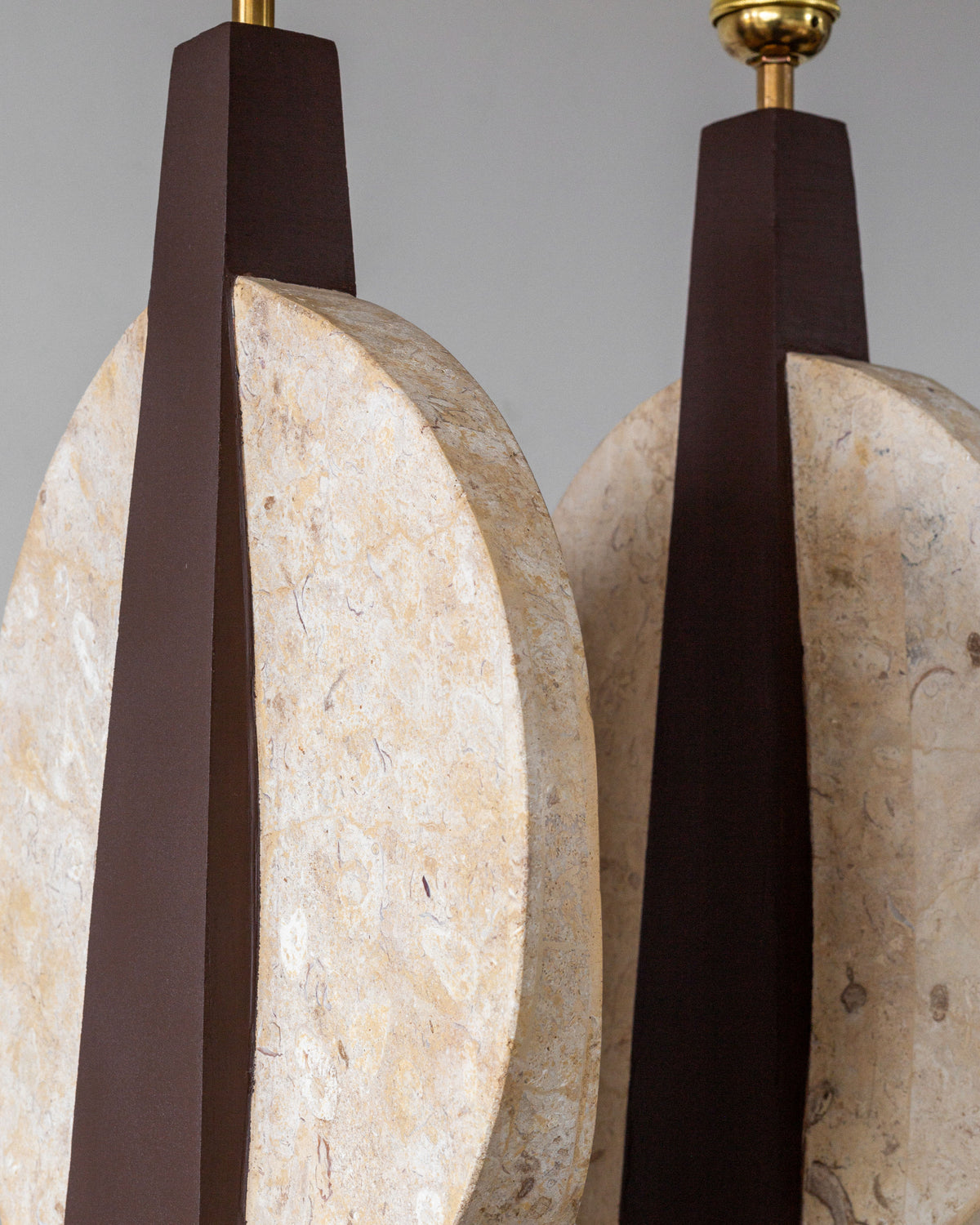 The Pair of Large Travertine Table Lamps by Spigel from the 1970s features vertical brown elements alongside textured stone-like discs, contrasting smooth brown and organic travertine-like surfaces for a striking visual impact.