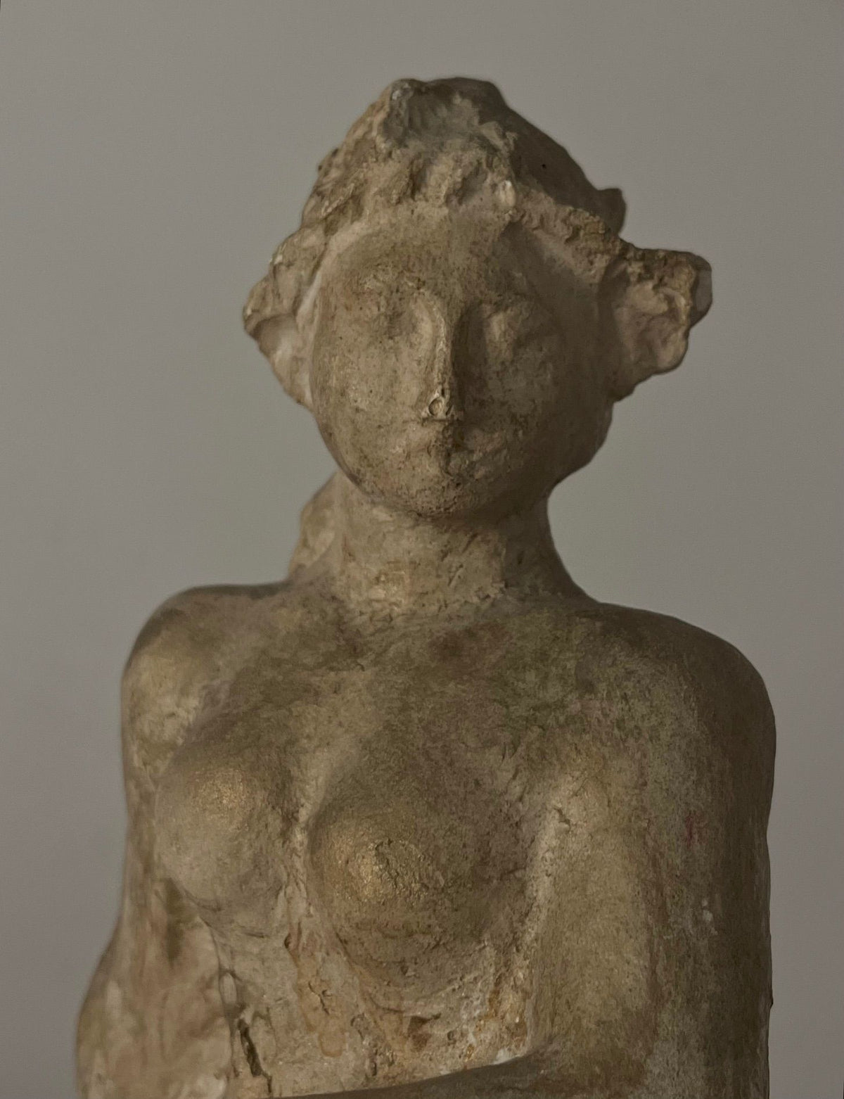 The Sculpture by Sakari Tohka 1938 from Médecine is a weathered plaster statue of a reclining female figure with defined breasts, delicate facial features, and visible surface cracks against a plain gray background.