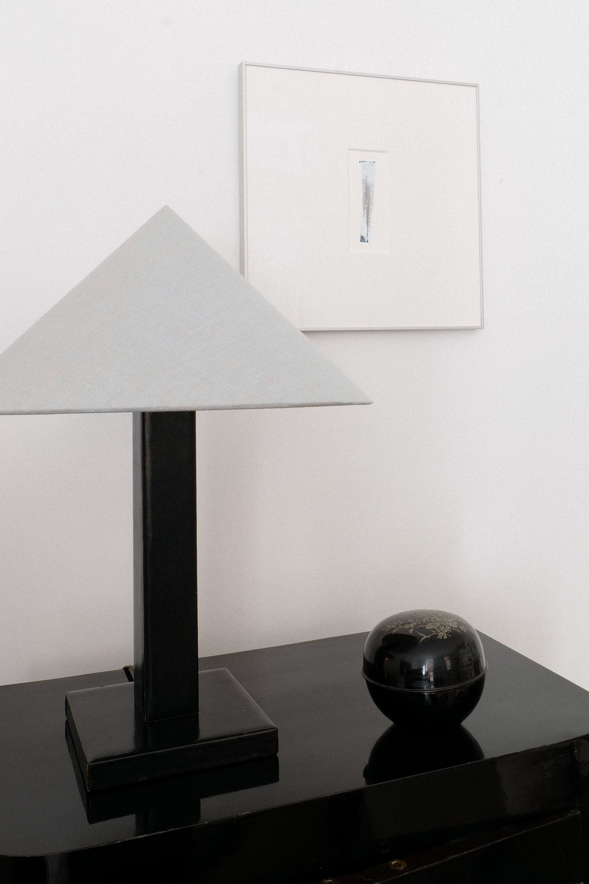 Adnet leather table lamp styled with black lacquer bowl on console