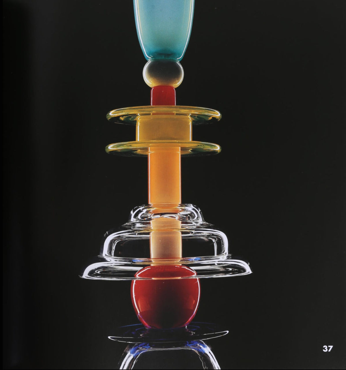 The "Ettore Sottsass, Glass Works Book" by Villa features a vibrant abstract glass sculpture with stacked geometric shapes in blue, yellow, orange, red, and clear glass on a black background; number 37 appears in the lower right corner.