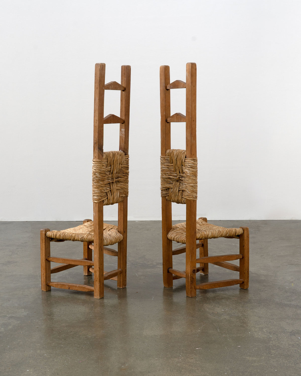 Two Chilean pine rush seat chairs with extended tall ladder backs