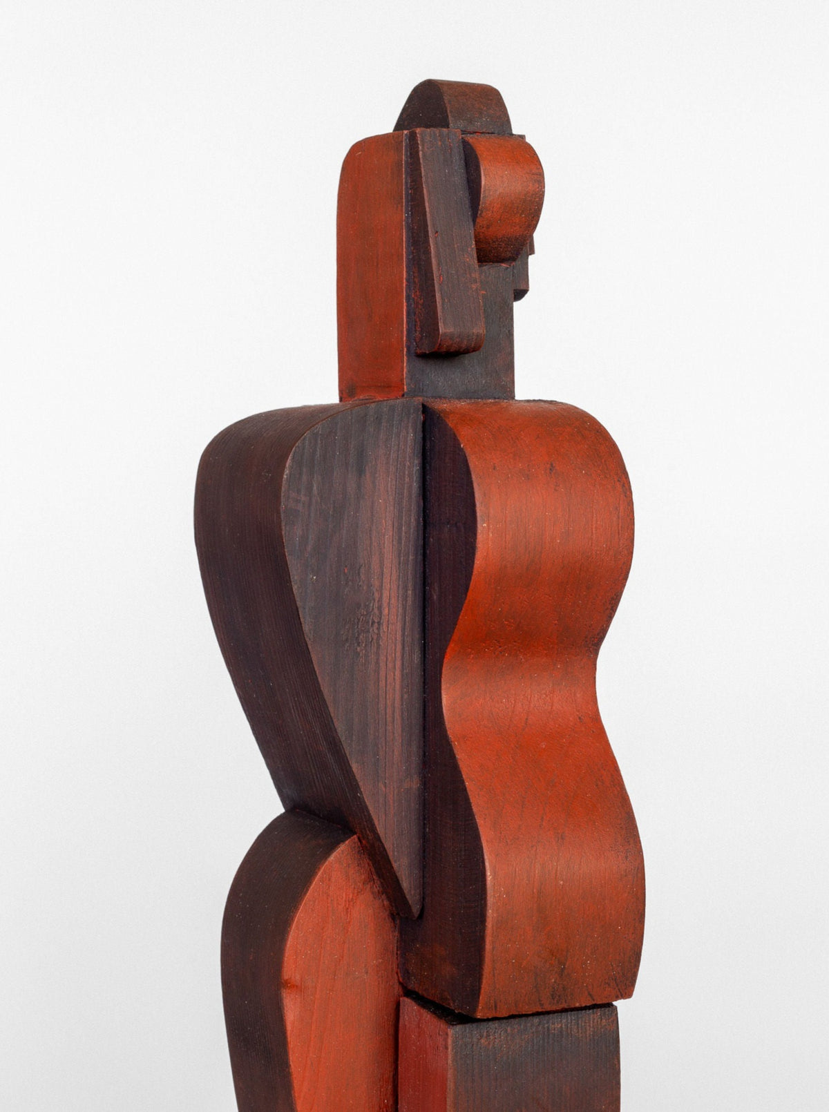 A Cubist Sculpture by Spigel of an abstract human figure, featuring smooth, curvilinear shapes with red and dark brown tones. The figure, viewed from the side, has simplified and geometric forms reminiscent of cubism, creating a modern, minimalist aesthetic against a plain white background.