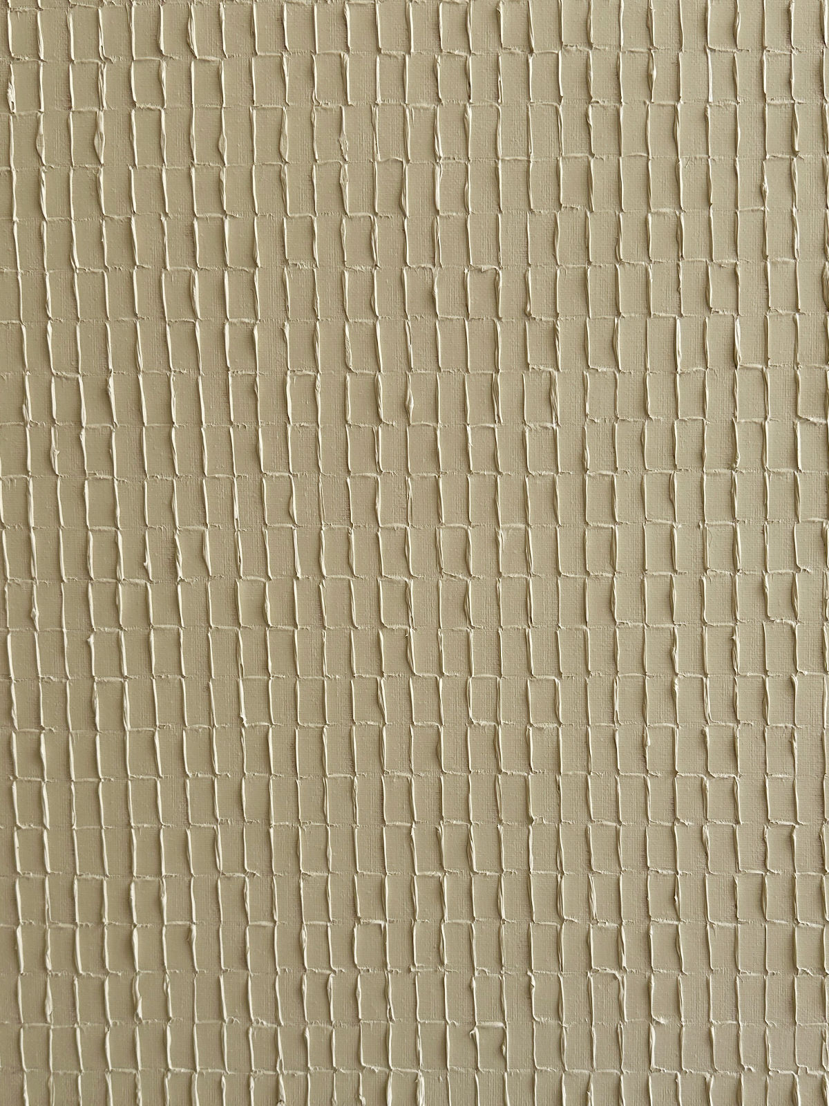 An image showing a textured wall with a grid-like pattern. The surface is beige in color and appears to be made of square or rectangular indentations, creating a tactile and visually interesting effect reminiscent of Korean Dansaekhwa, encouraging mindfulness through its organic forms. This piece is titled Buff Titanium - Oil on canvas by Roi Elmaliah.