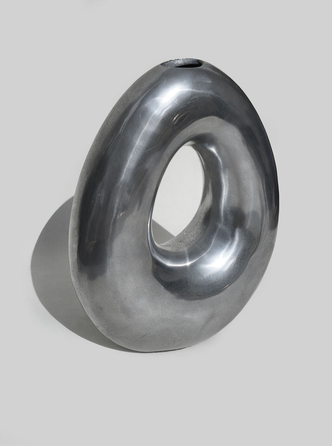 Curved ceramic circular vase in metallic gray finish detail view