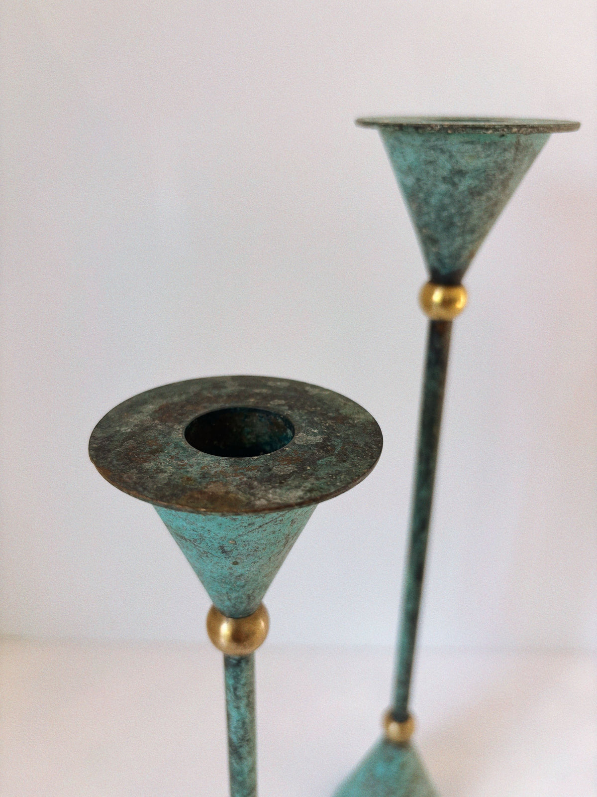 Close-up detail of verdigris brass postmodern candleholders