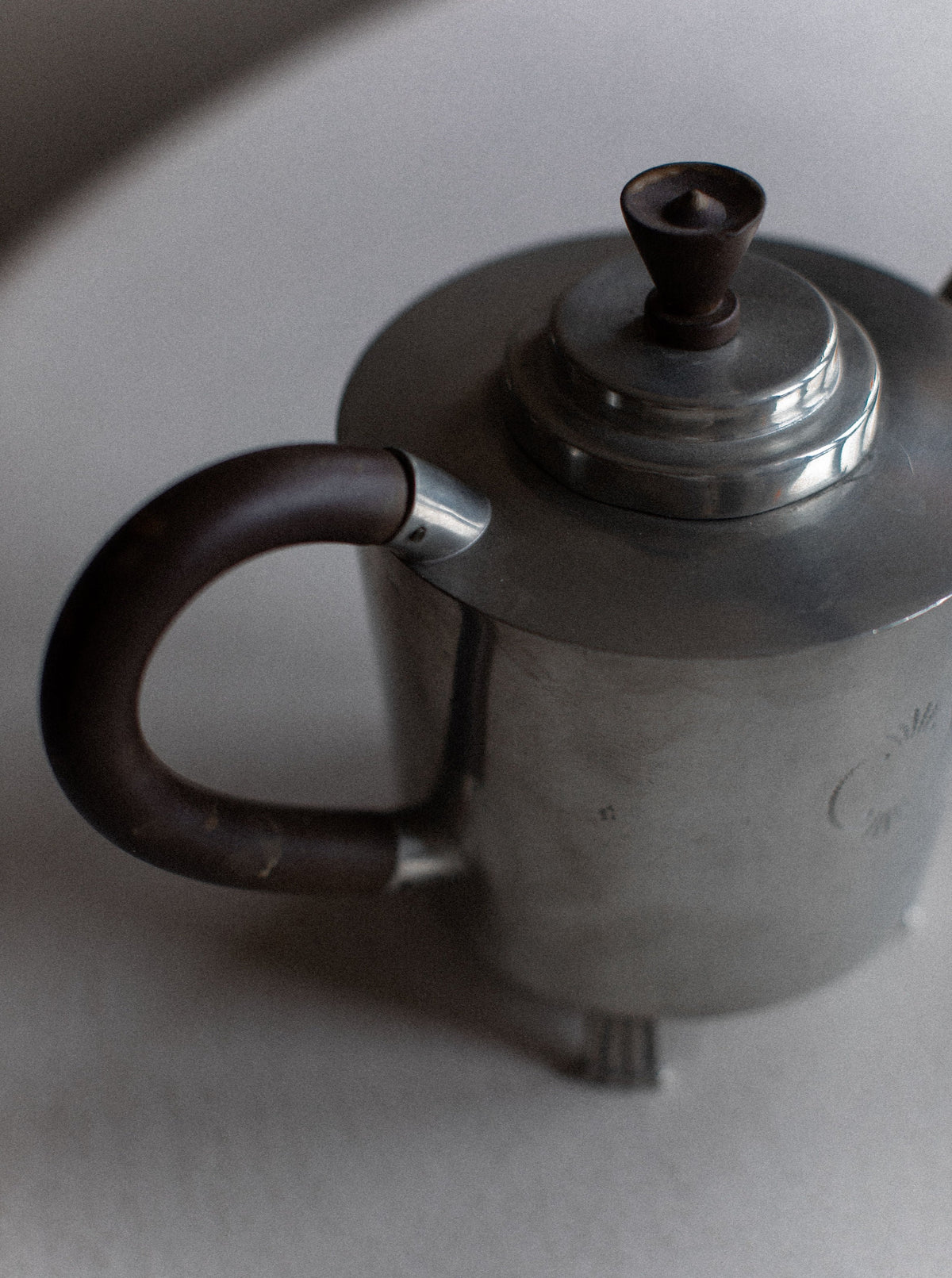 An Art Deco Swedish Grace Tea-set from Out For Lunch is placed on a light-colored surface. The tea-set exudes minimalist charm with its sleek design and slightly worn appearance, embodying a simple, functional look that hints at Swedish grace.