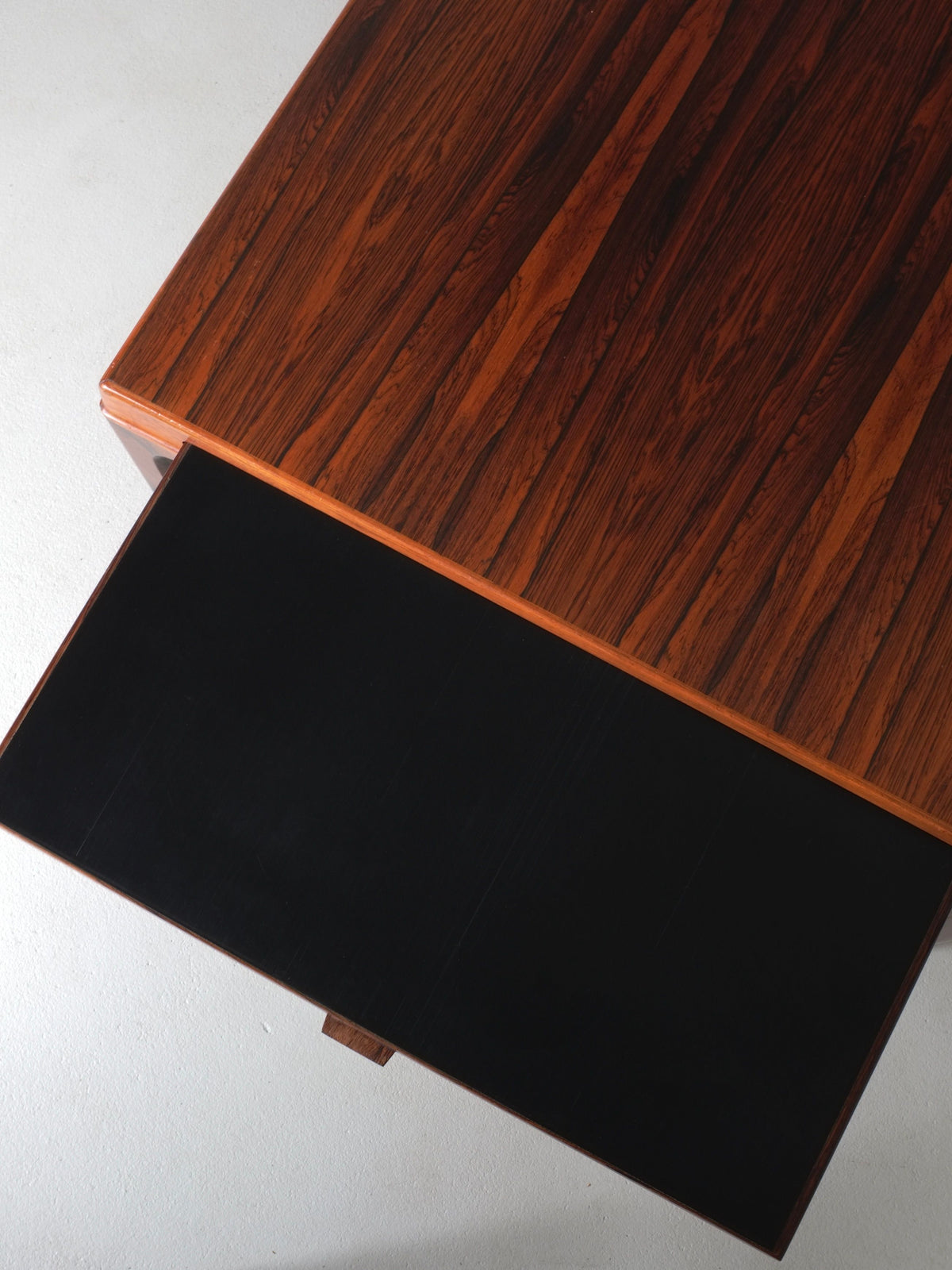 Rosewood coffee table detail showing rich wood grain and black compartment