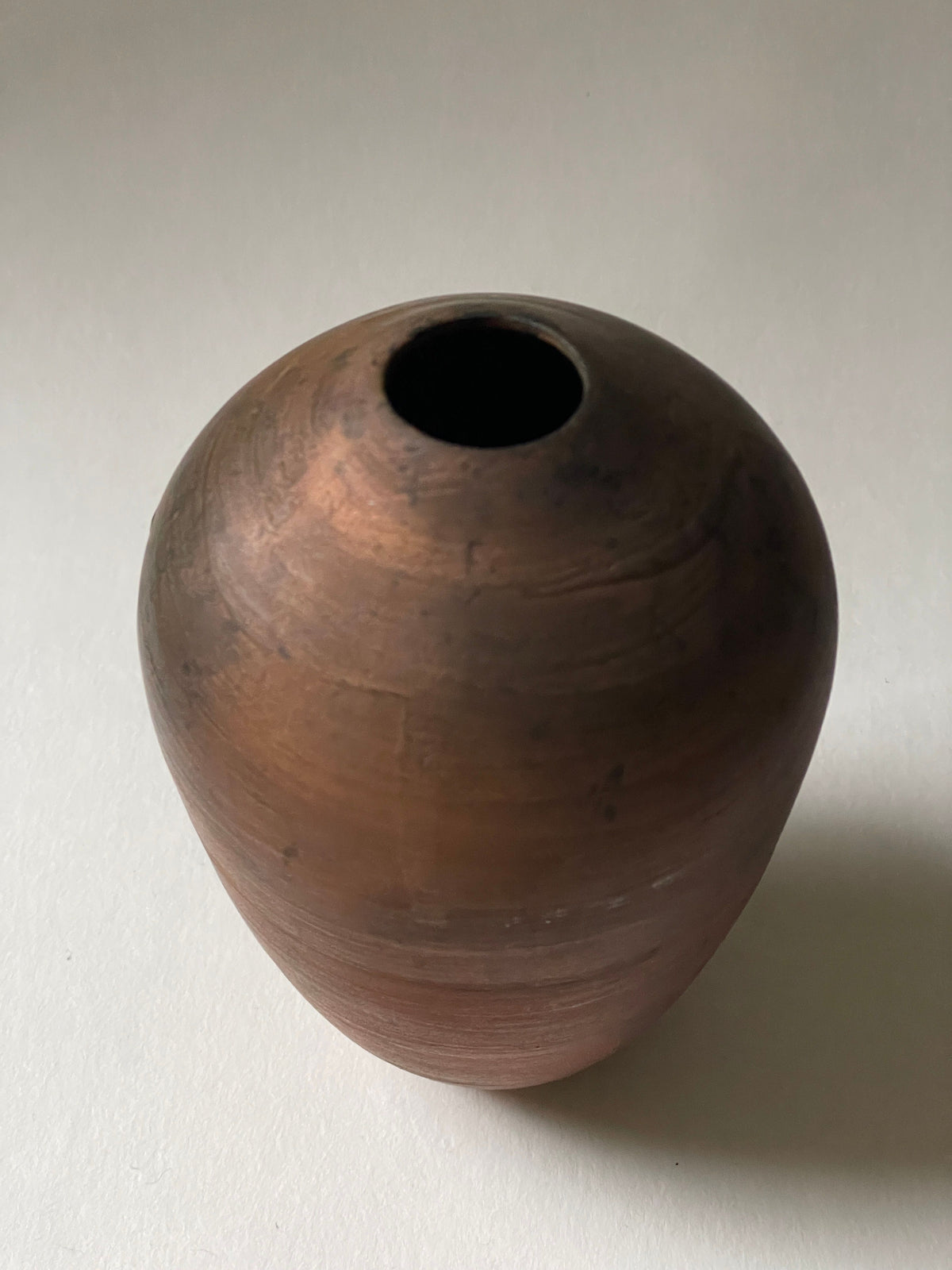 Small brown pottery vase with natural wood grain texture detail
