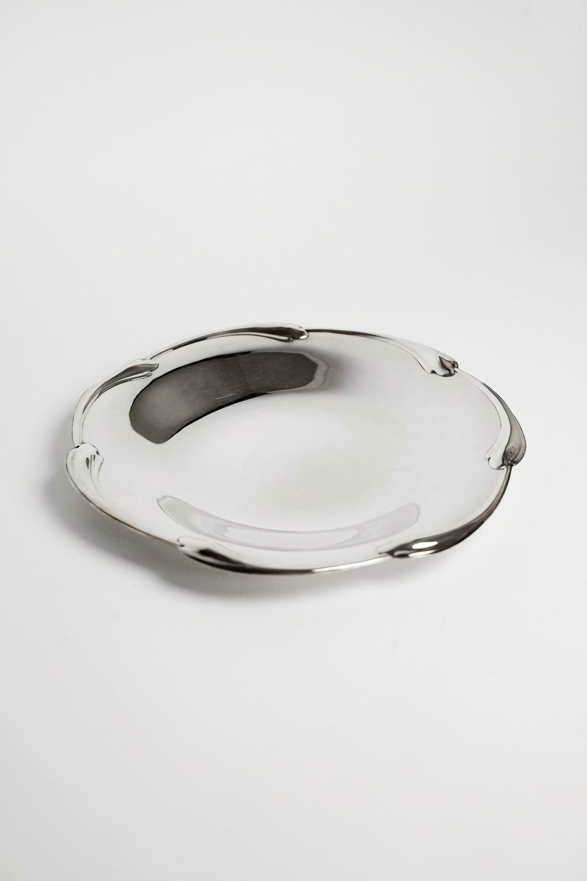 The septembre studios Large silver-plated dish features a smooth surface and a scaled rim, displayed on a plain white background.