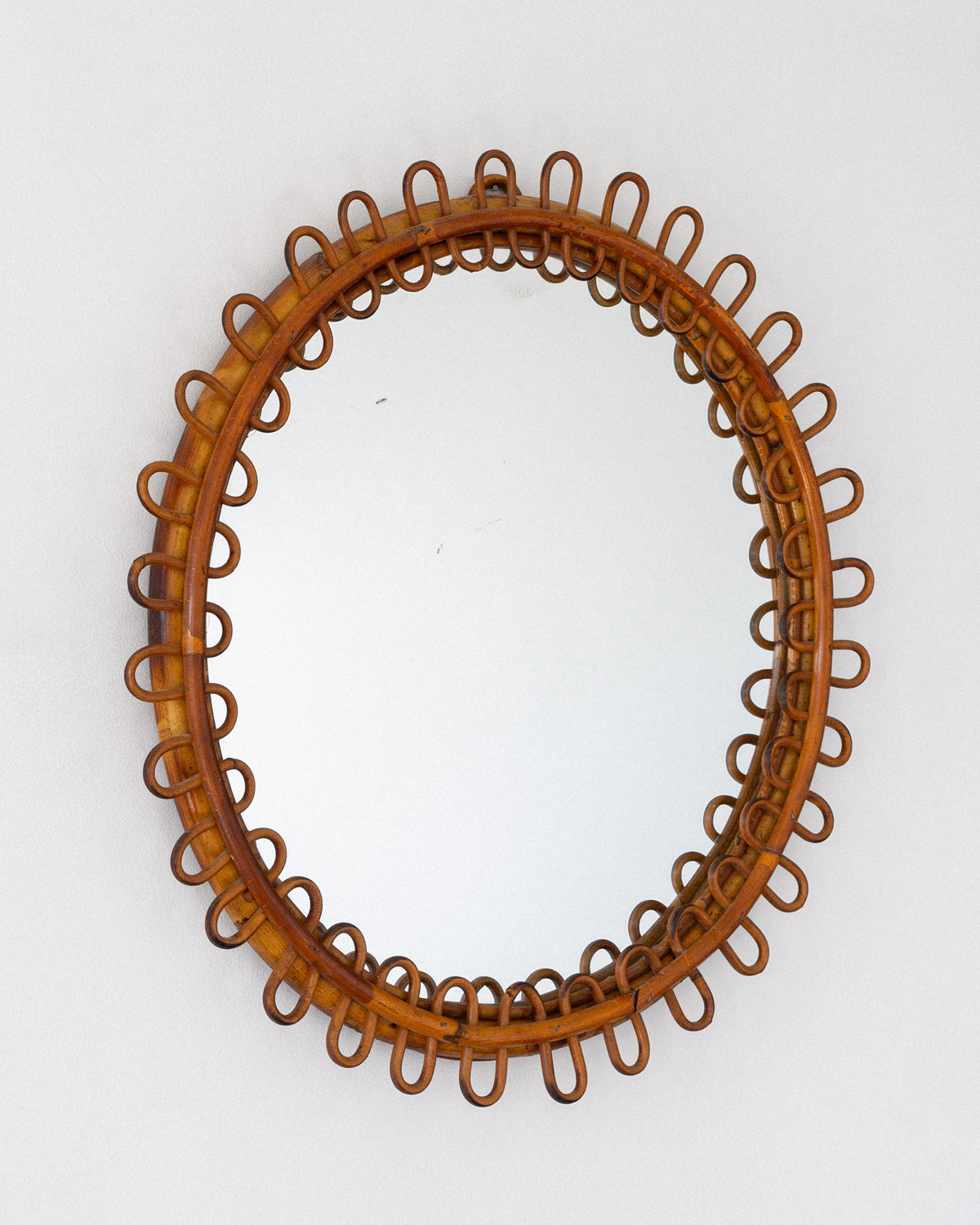 Oval rattan mirror with decorative loop frame by Franco Albini