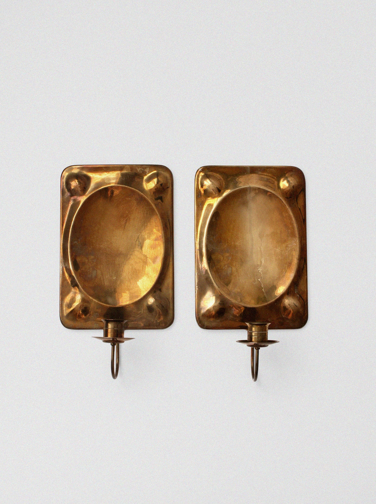 Pair of brass wall candle sconces with oval reflector backs