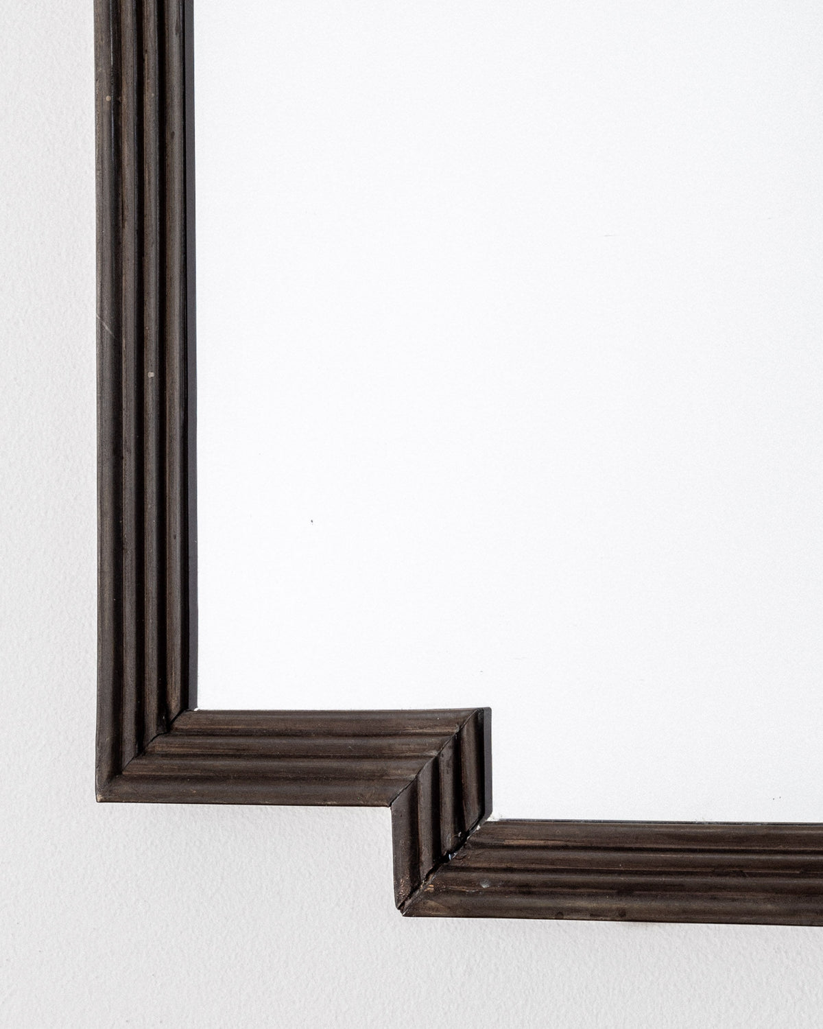 Bronze Art Deco mirror frame corner detail showing fluted molding
