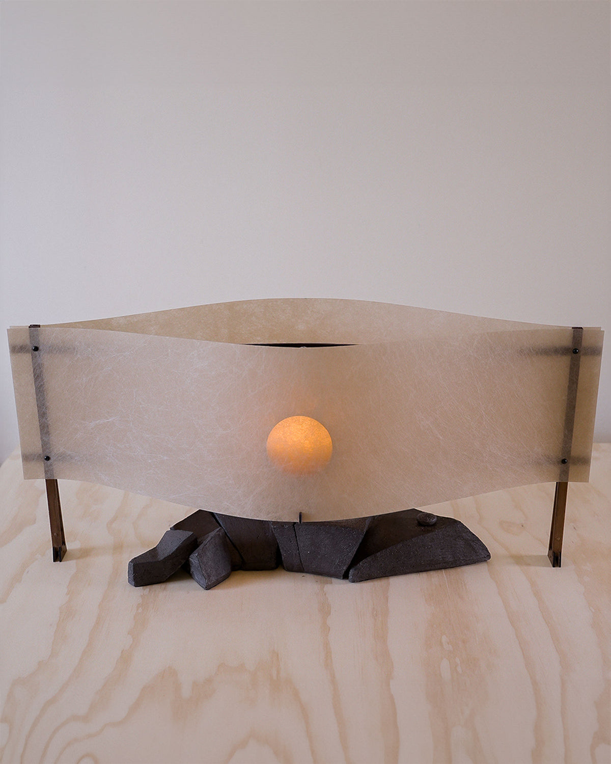 Sunrise sculptural table lamp with curved translucent shade and coal base