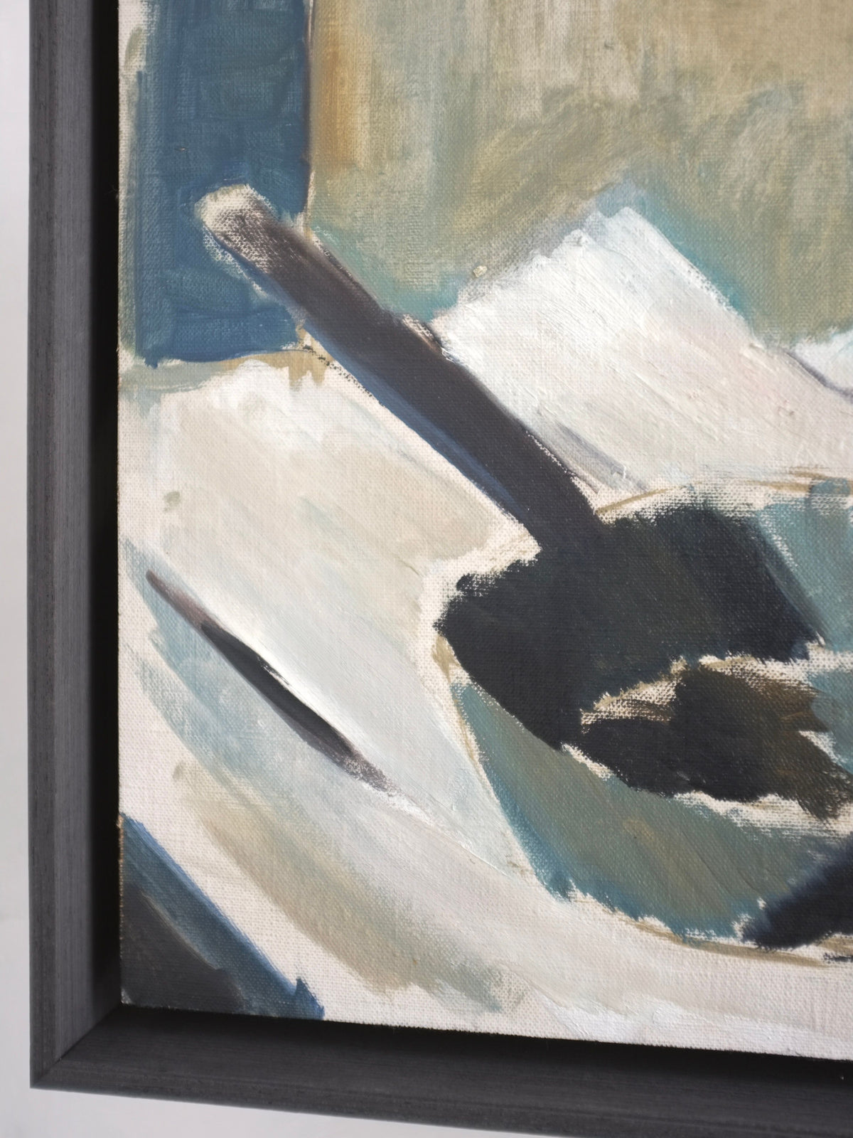 A close-up view of Veter Vintage's framed abstract painting, "Breakfast," primarily in muted shades of blue, gray, and white. The 1960s Swedish oil painting features dynamic brushstrokes and an indistinct shape that might resemble a spoon or paddle. Encased in a dark, minimalist floating frame, it evokes the elegance of vintage still life art.