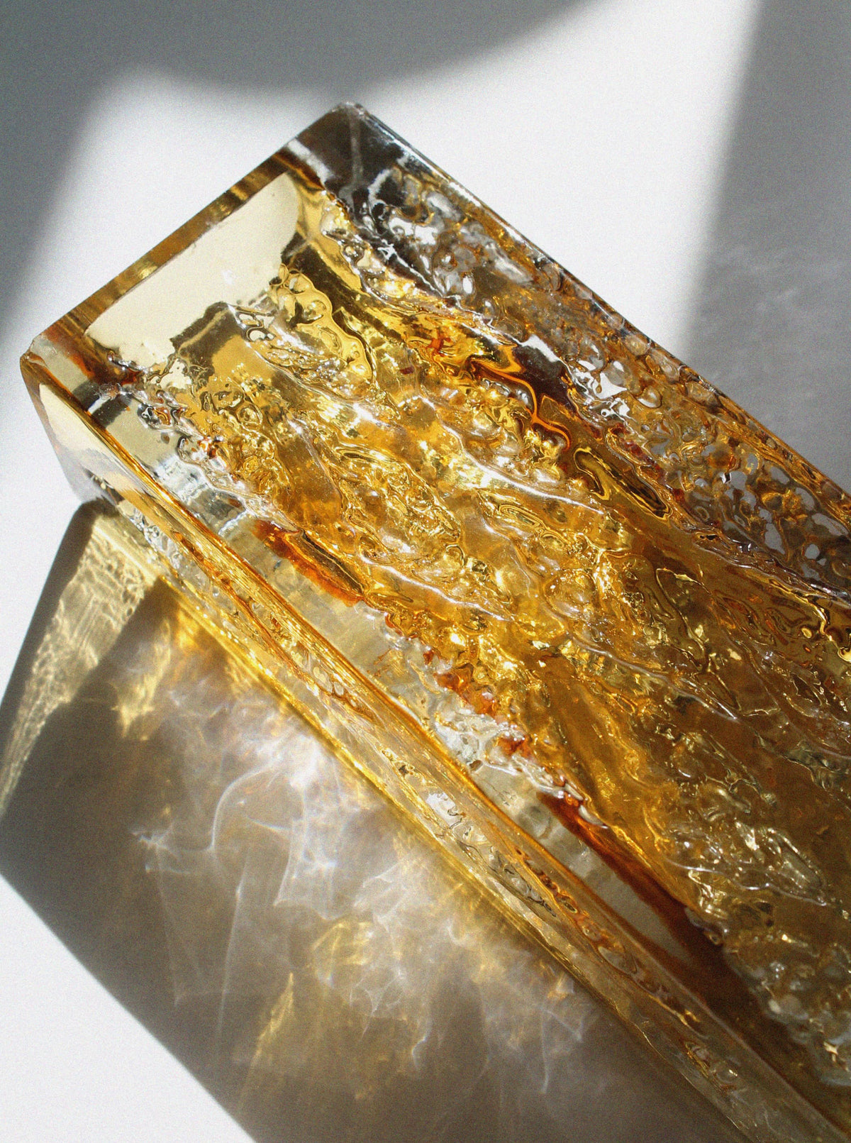 Close-up detail of Kurt Wokan amber crystal glass vase texture