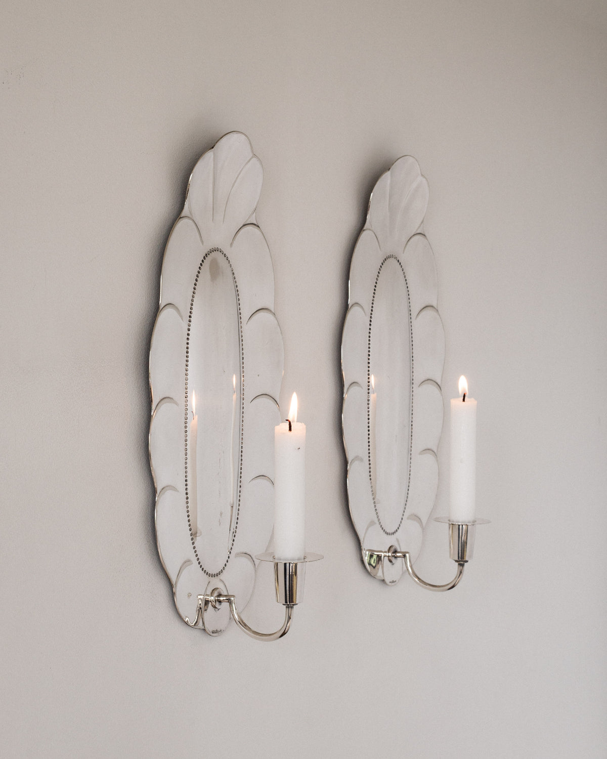 Pair of 1930s silver scalloped shell wall sconces with lit candles
