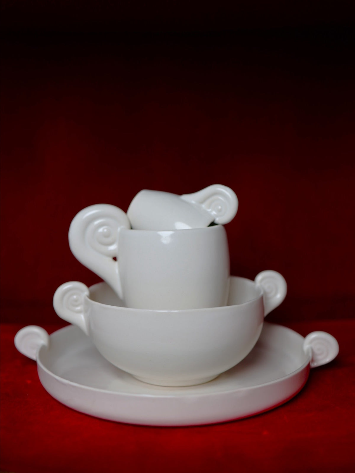 White ceramic bowl with curved horn-like handles, stacked view
