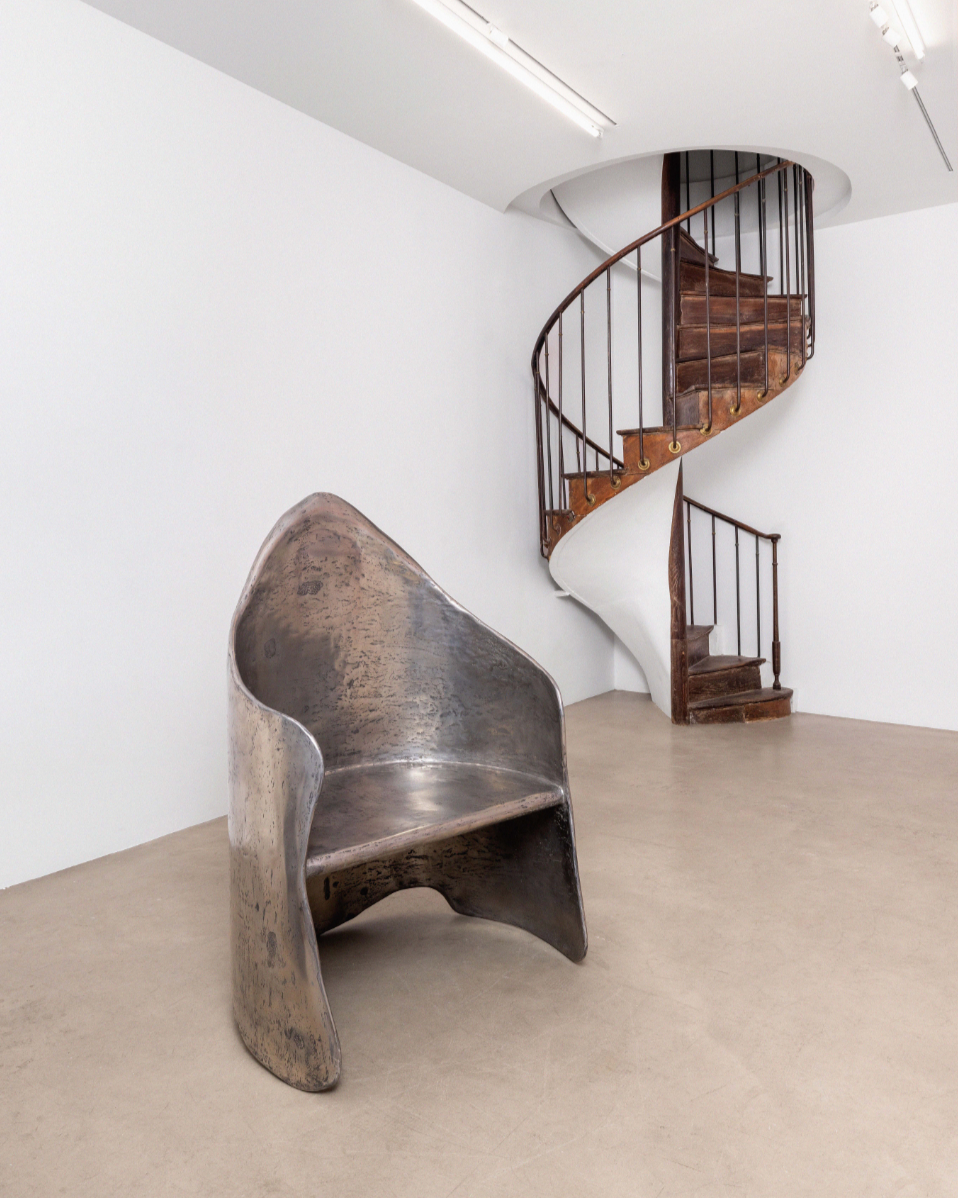 AMAIA polished aluminum-brass resin chair in minimalist gallery setting