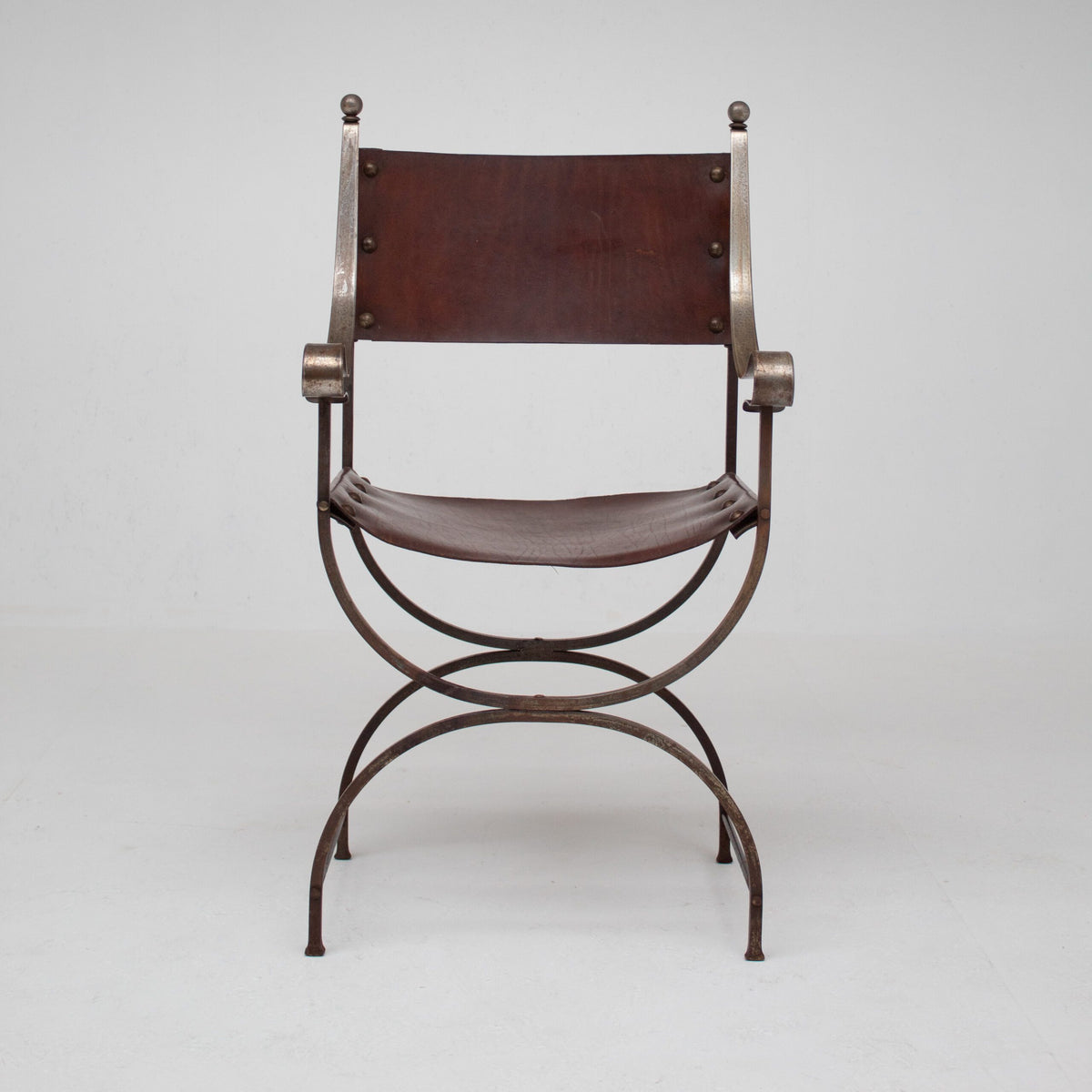 French pair of Iron Curule Chairs in Leather — front view on white background