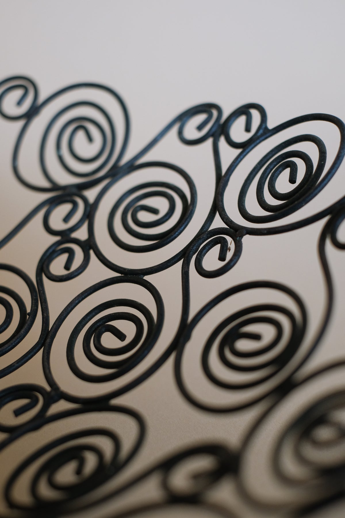 Close-up detail of decorative wire bowl's spiral metalwork pattern