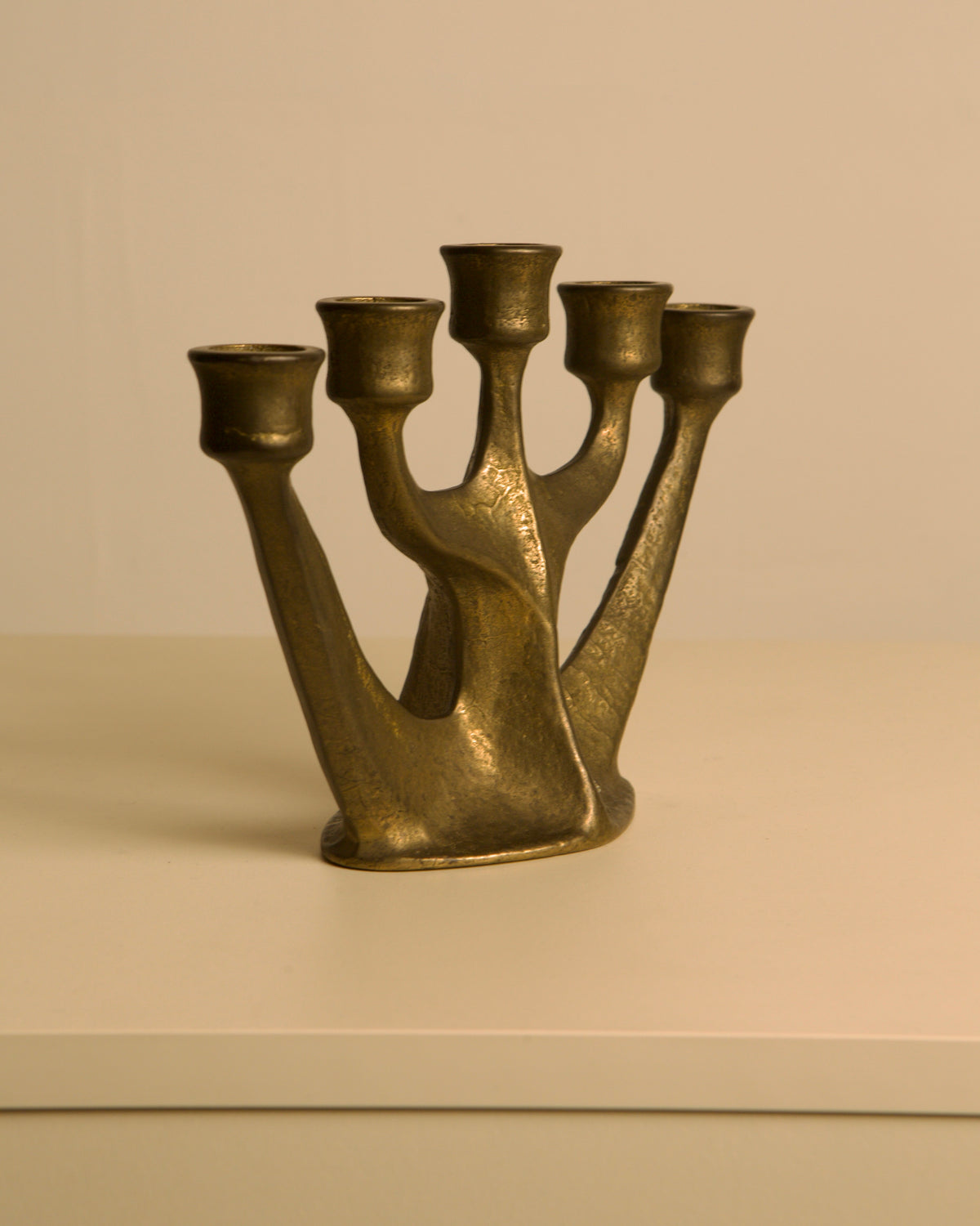 Five-branch Brass Candleholder by Michael Harjes, 1960s — angled view on white surface