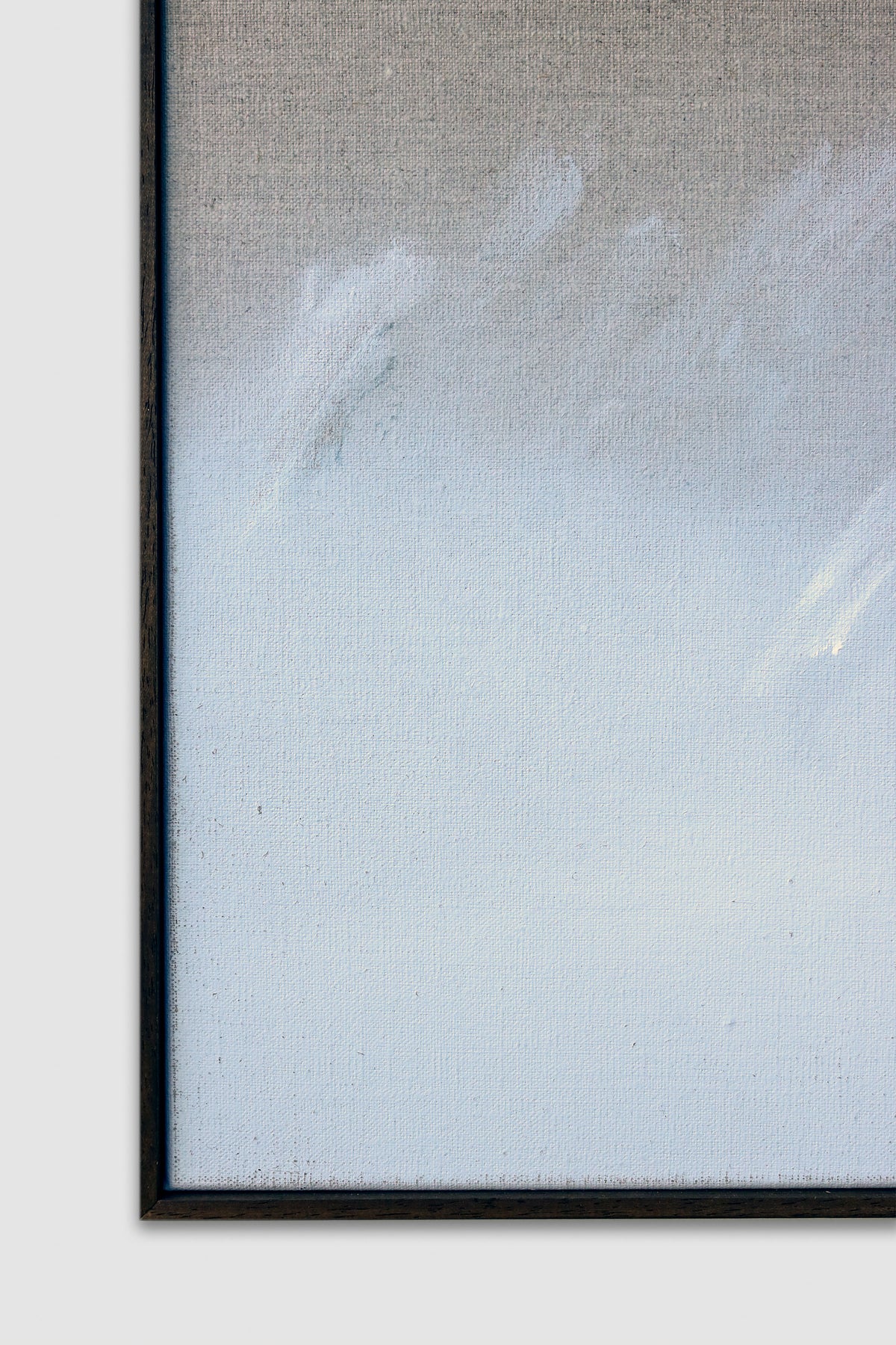 A close-up of "Holding — Acrylic on Linen" by David Hardy in a black frame, showcasing soft, abstract white and light gray brushstrokes on a textured beige background.