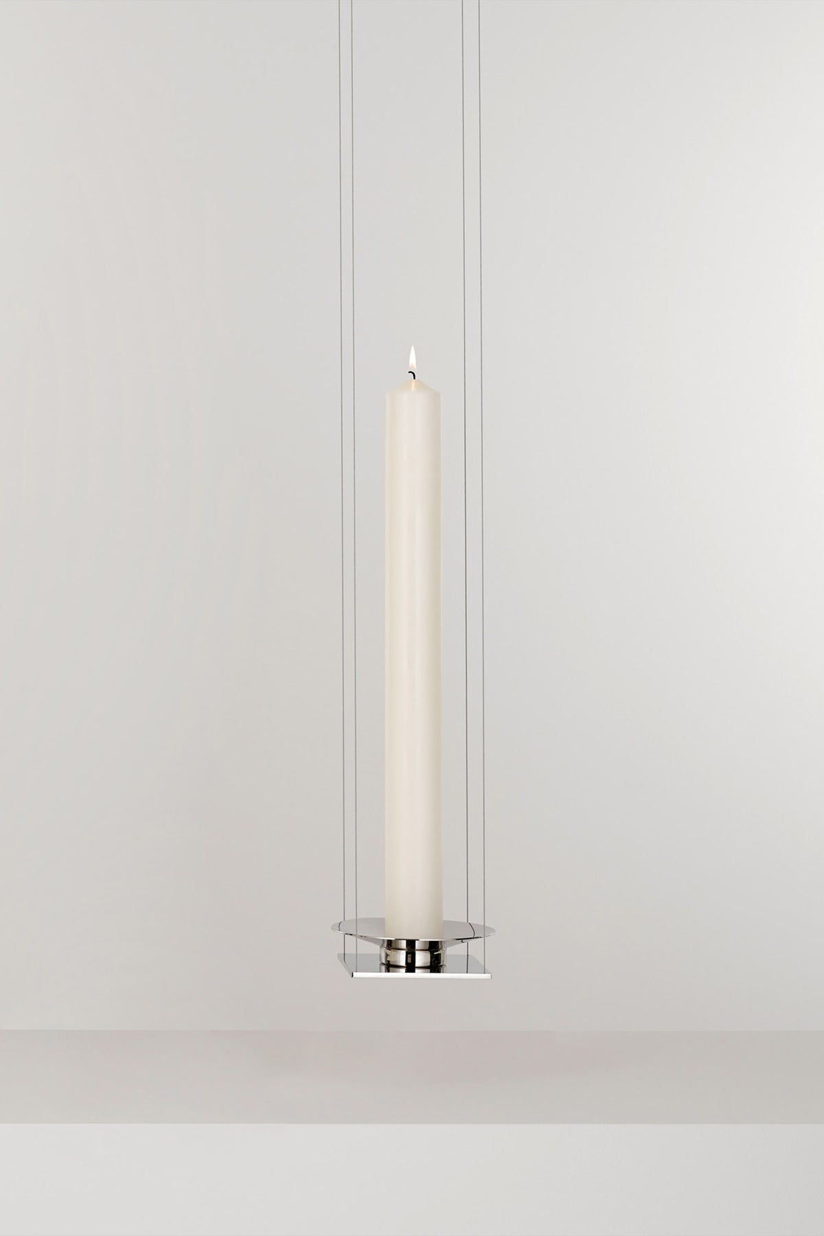 WAN PENDANT — close-up of white candle in chrome holder