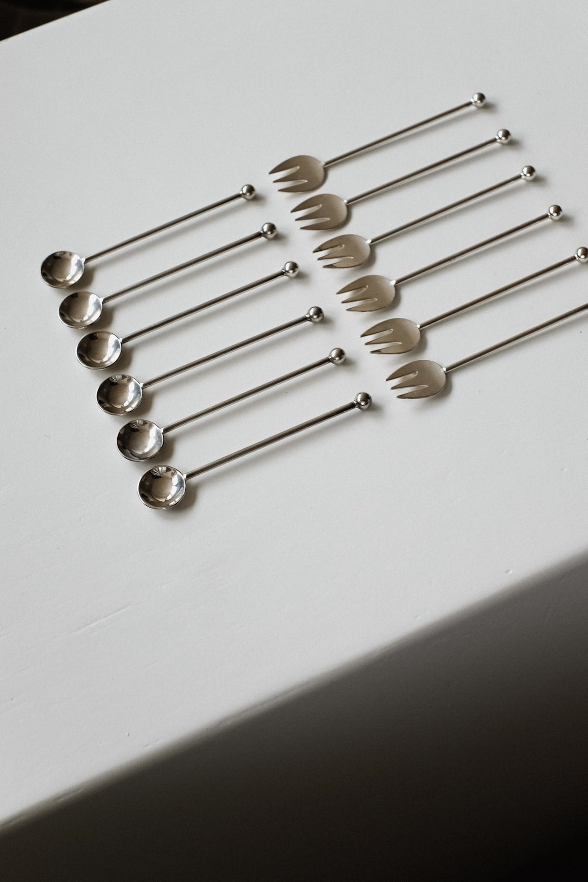 Silver-Plated Cutlery Set — arranged on white tablecloth in flat lay