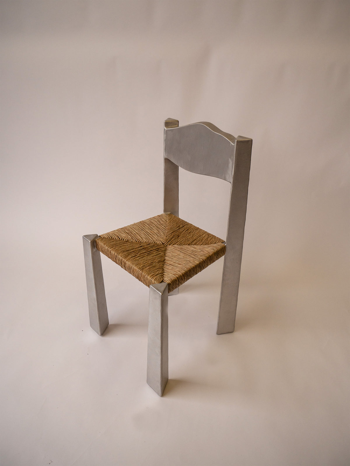 Woven Chair — angled view highlighting woven seat and metal legs