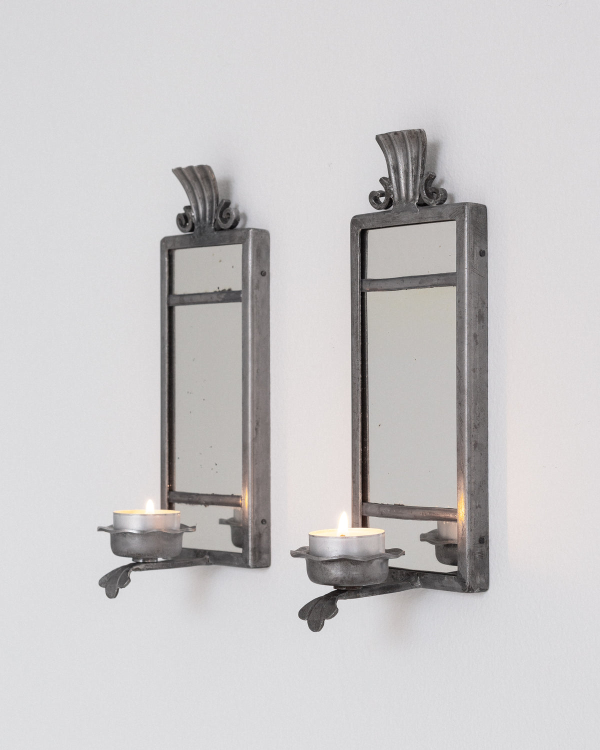 Pair of Art Deco Pewter Candle Sconces by Böhlmarks, Sweden, 1930s — mounted on white wall with lit candles