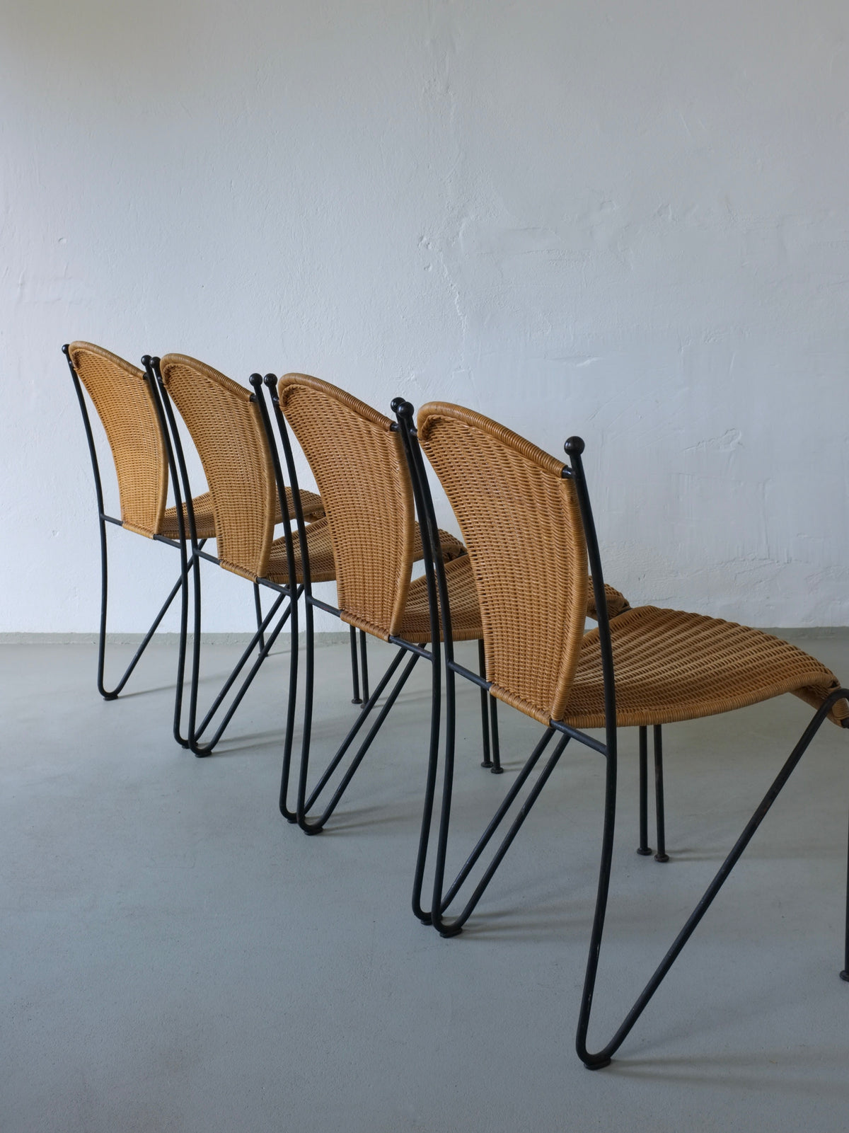 Four 1960s Frederick Weinberg wicker chairs with black iron frames