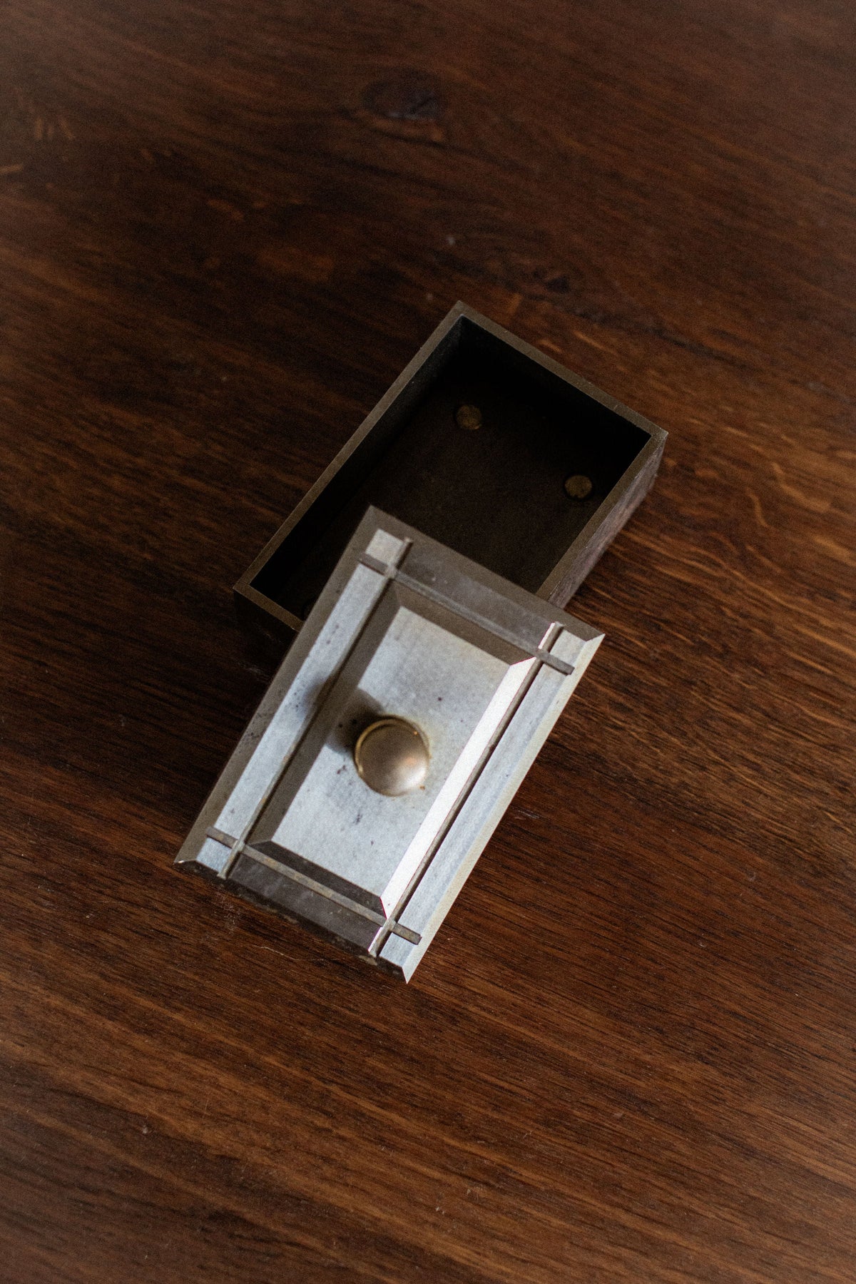 Industrial metal storage box with hinged lid and brass knob detail