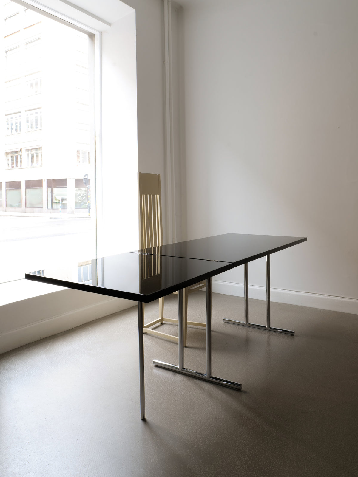 Modern black glass dining table with chrome legs by Eileen Gray