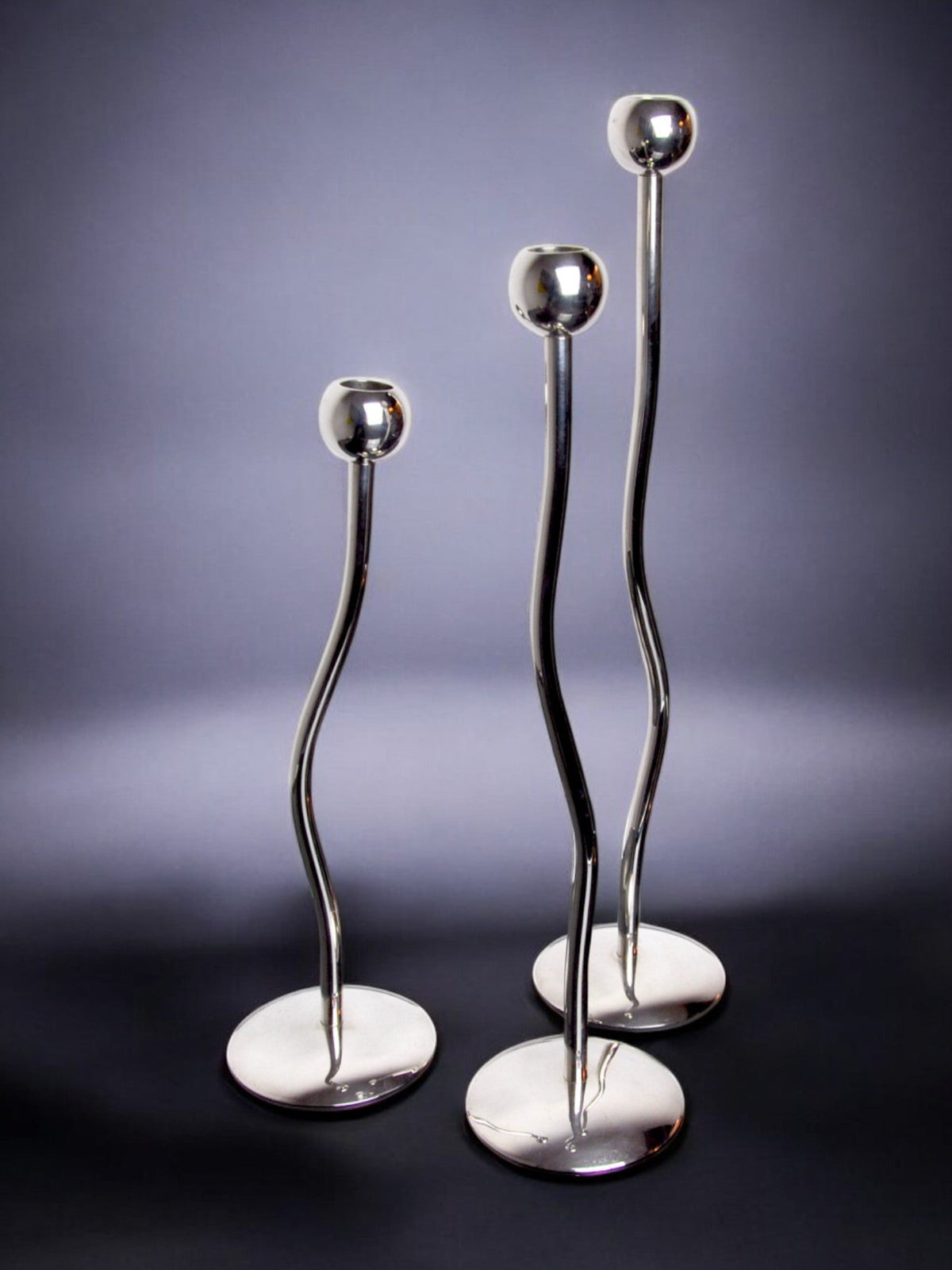 Trio of silver metal candlesticks from mesa italy, italy, 1980s — lifestyle setting