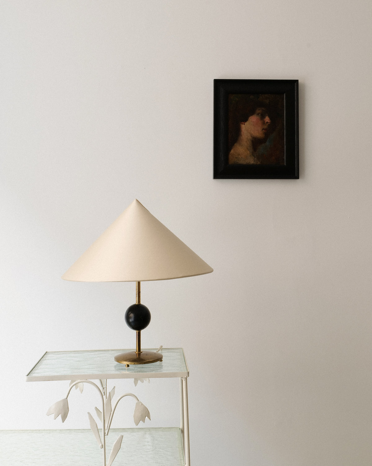 Victorian portrait painting displayed above modern conical table lamp