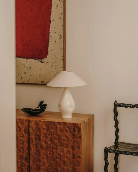 Beige conical table lamp styled on carved wood cabinet