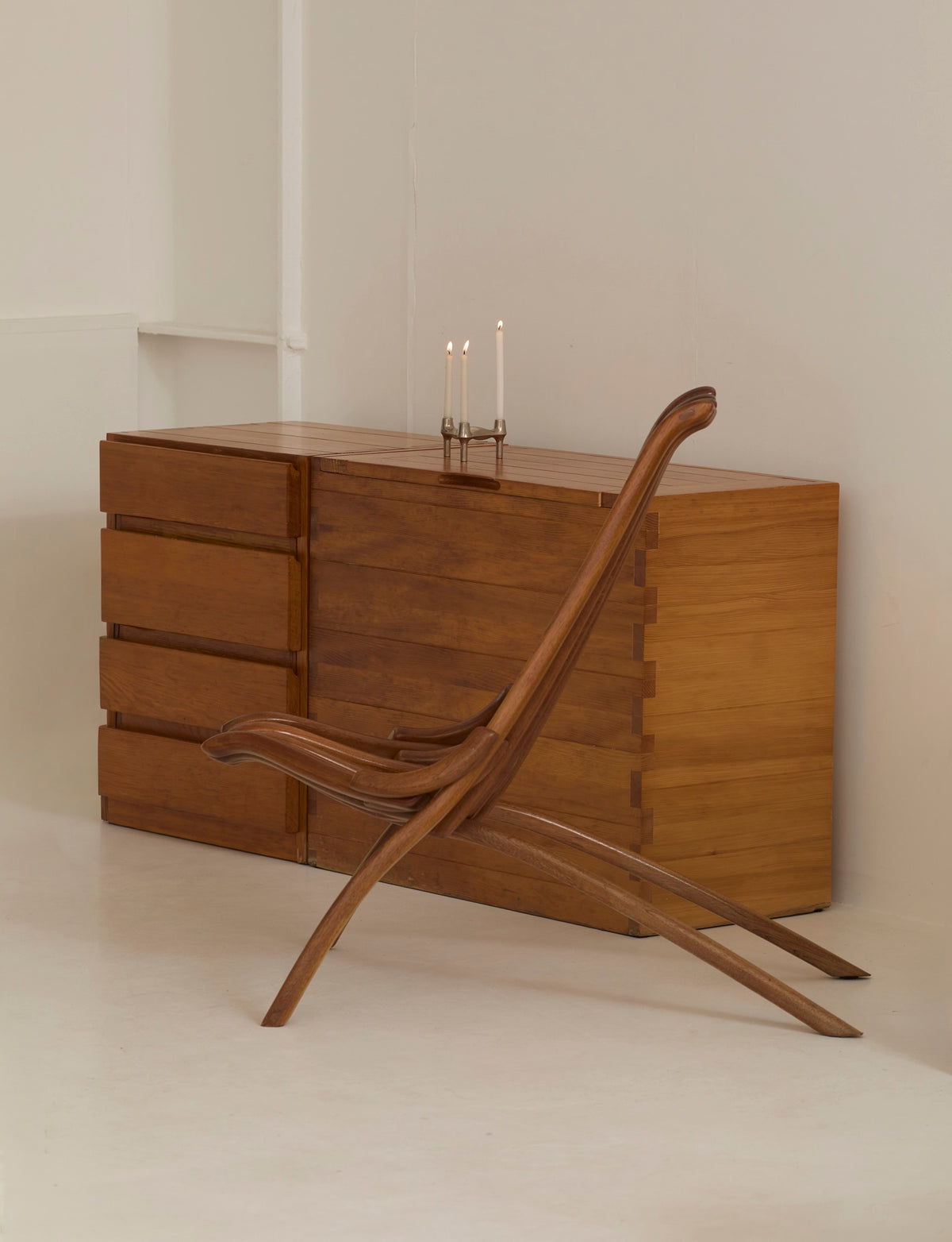 Vintage Artisanal Foldable Lounge Chair in Wood — side angle with wooden legs against light wall