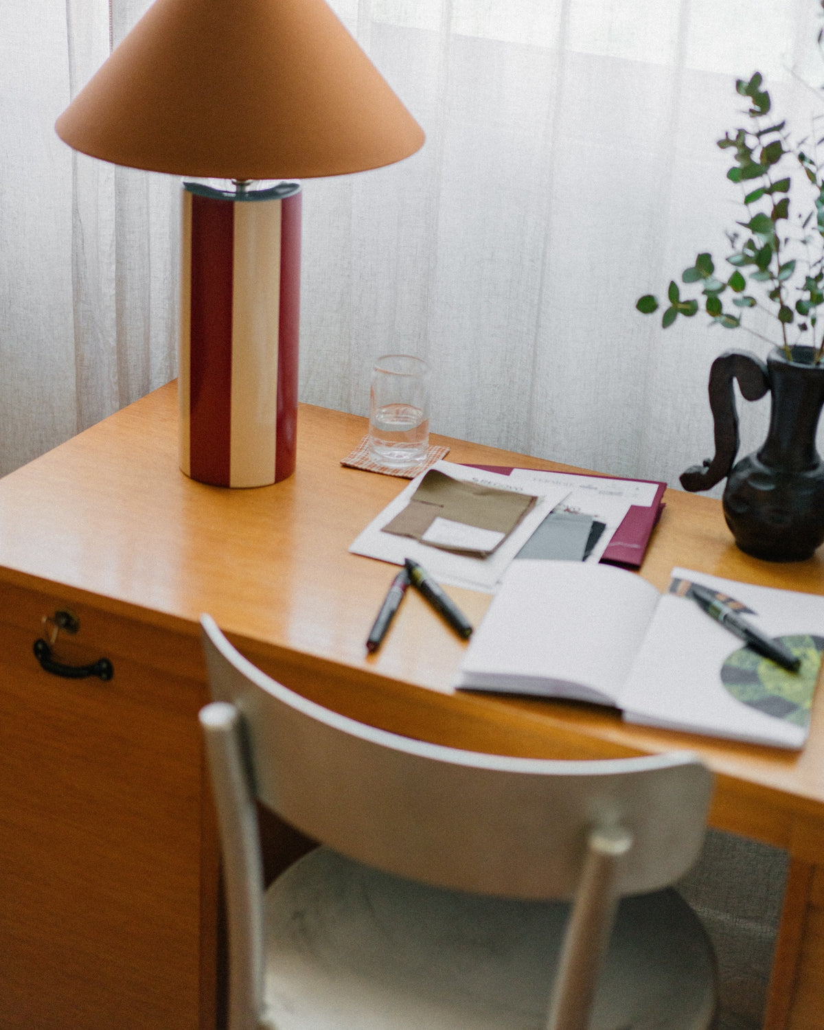 Ombrellina" Table Lamp - Oxblood & Cognac — side angle on wooden desk with stationery