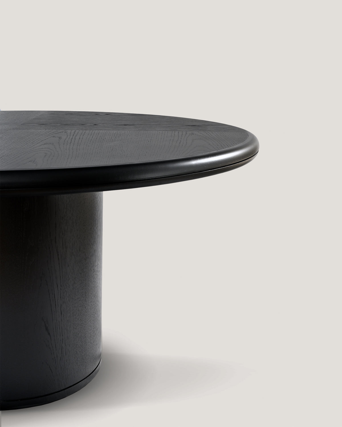 Close-up detail of Moon round dining table edge in black oak