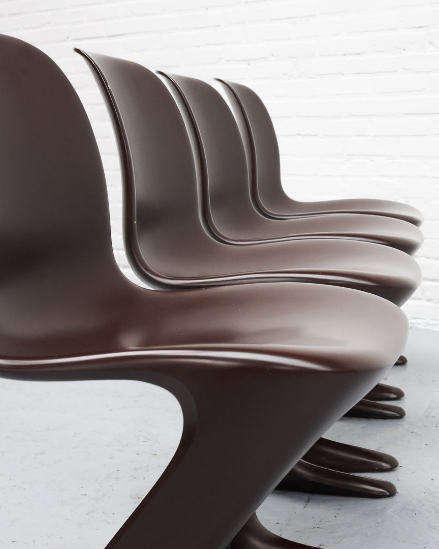 Row of brown molded plastic Z chairs showing curved cantilever profile