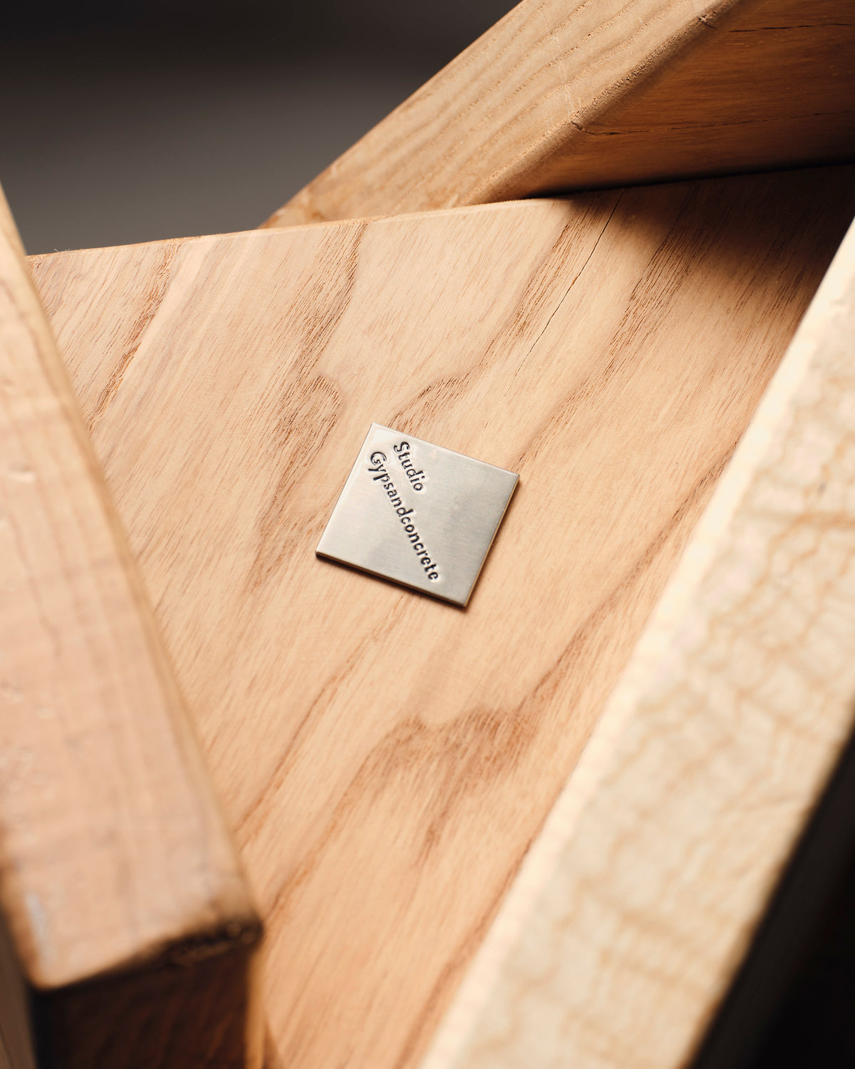 Maple stool crafted by Studio Gypsandconcrete with branded metal tag