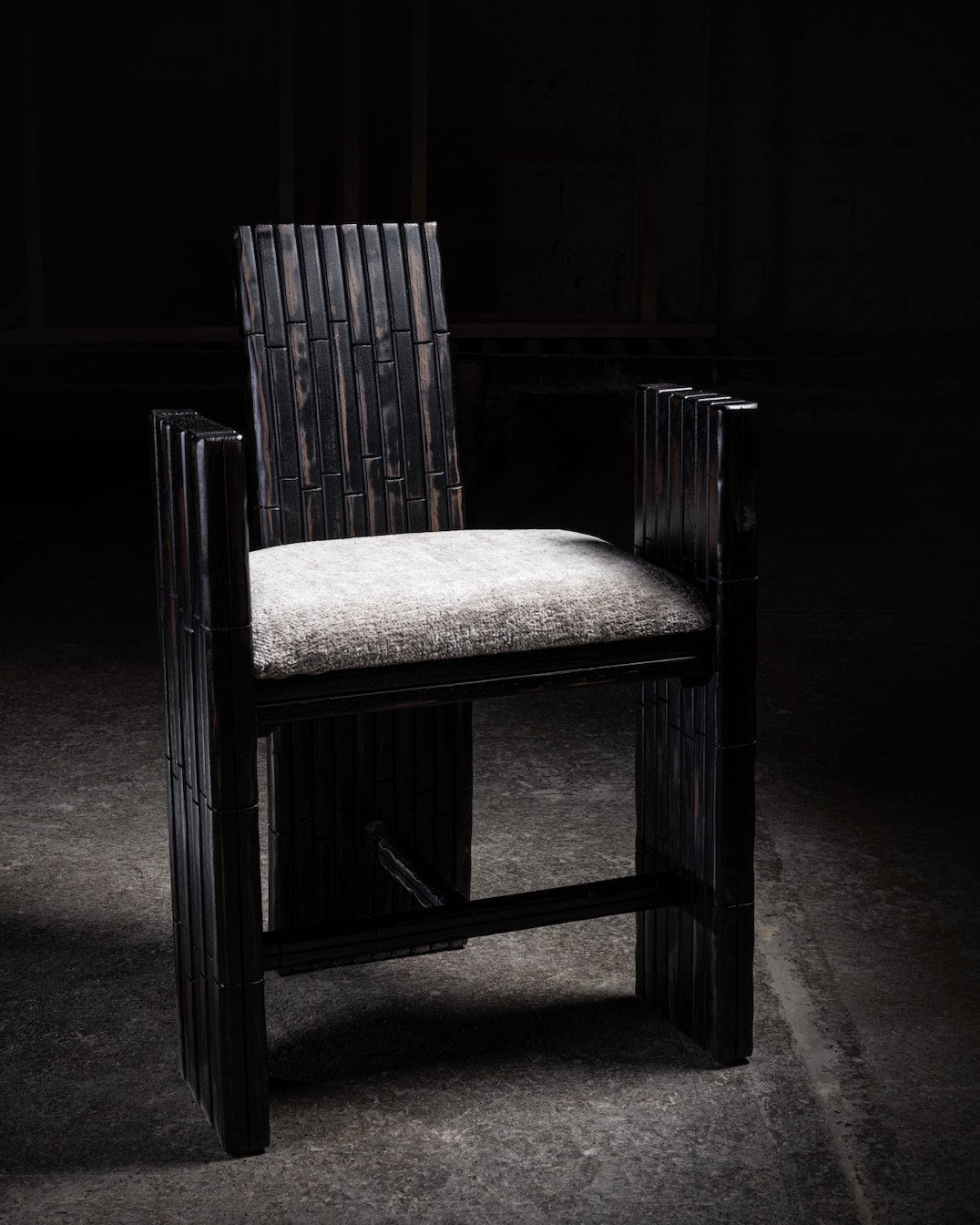Dark bamboo armchair with woven backrest and neutral cushion